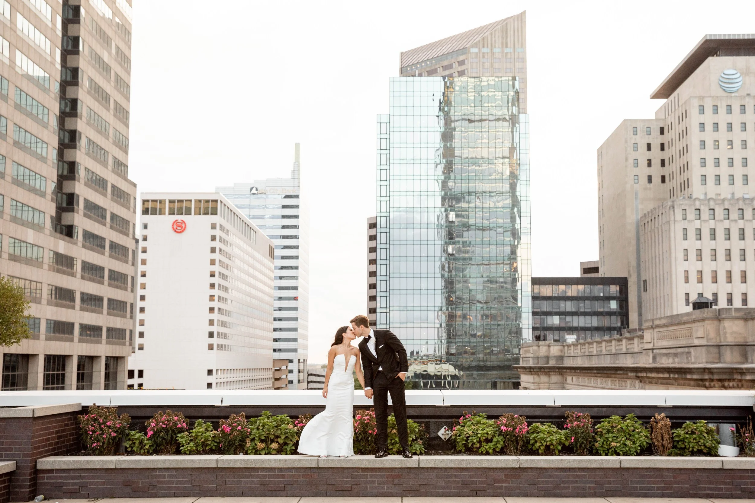 Sunset couple portrait on the penthouse terrace at JPS Events at Regions Tower in downtown Indy. Offers iconic 360 skyline photo ops near Monument Circle, 6 walkable hotels, & hands-on family coordination.