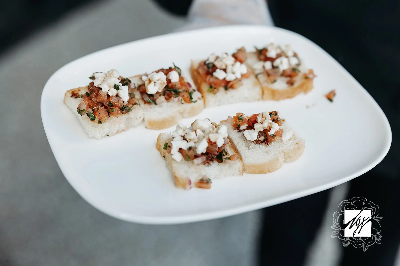 Optimized Alt Text:

Close-up of a white plate with small pieces of sliced bread topped with finely chopped vegetable relish and crumbled white cheese—passed hors d'oeuvres by luxury in-house catering at JPS Events at Regions Tower in Downtown Indy.