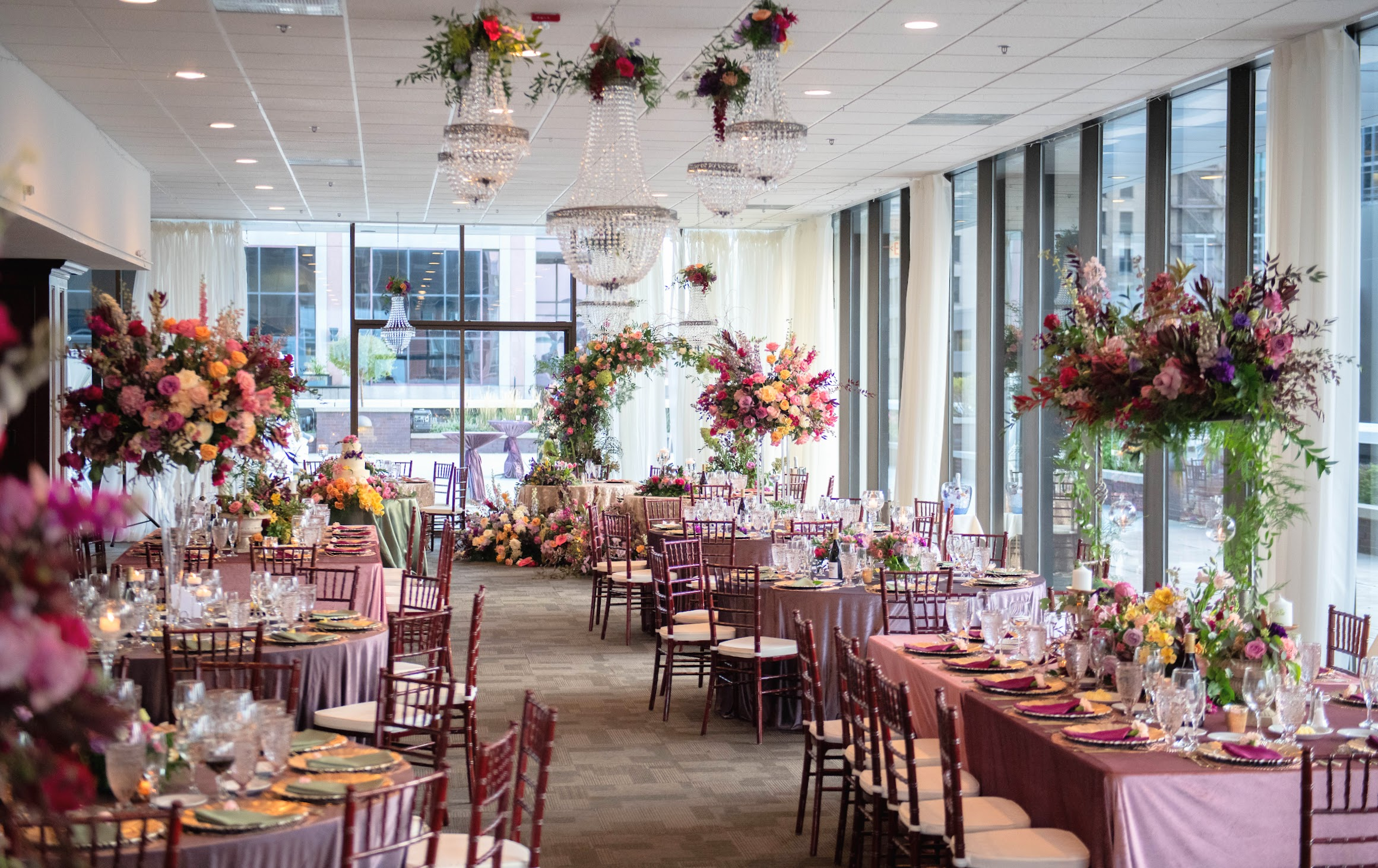 Luxury indoor ballroom wedding reception for 100-300 guests at JPS Events at Regions Tower, featuring floor-to-ceiling windows, 360 skyline views, crystal chandeliers, and in-house floral design in downtown Indy.