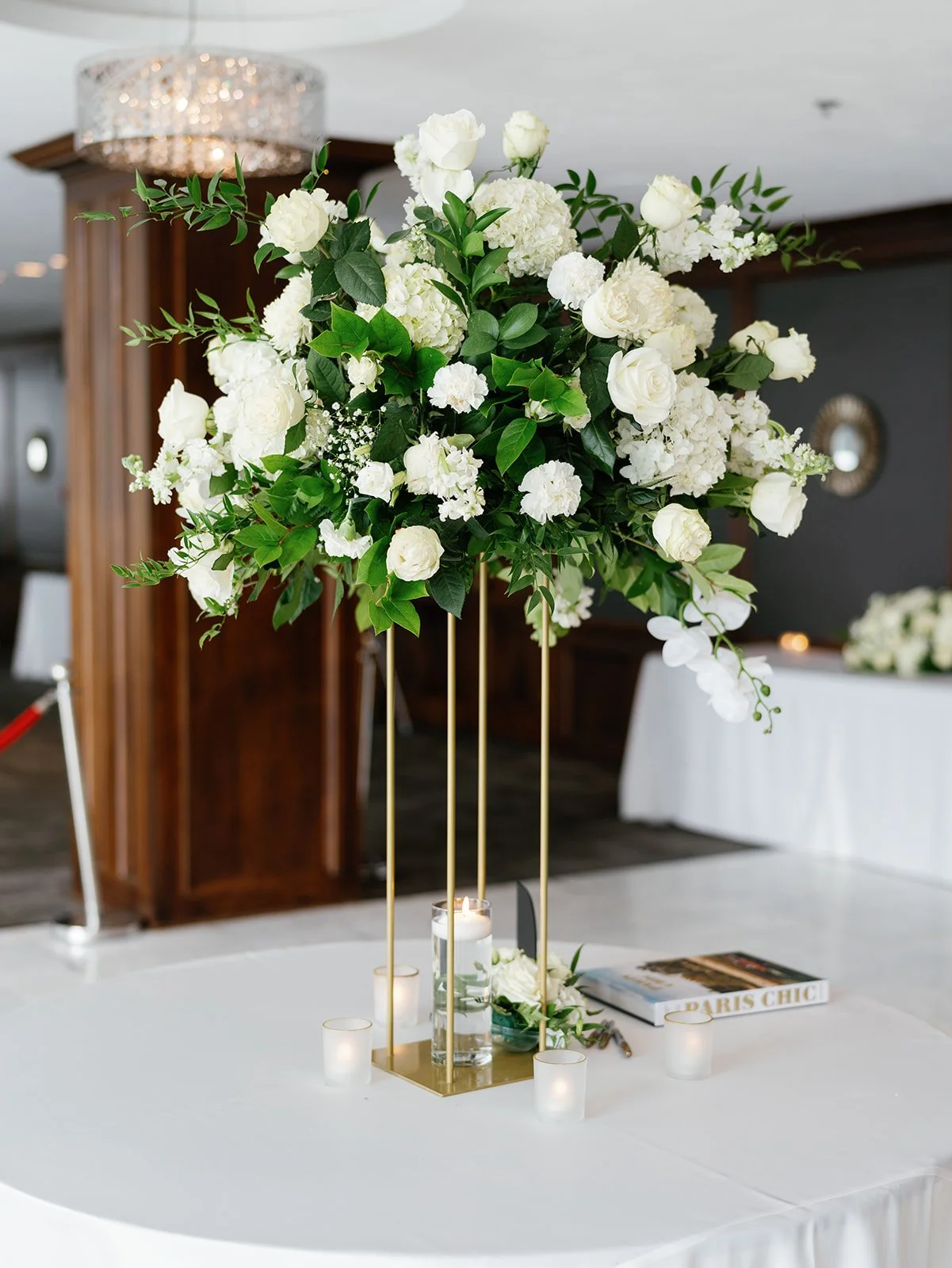 Tall white rose centerpiece at JPS Events at Regions Tower. Highlights modern metropolitan chic interior with dark wood paneling, polished white marble floors, & over-the-top in-house floral design at wholesale pricing