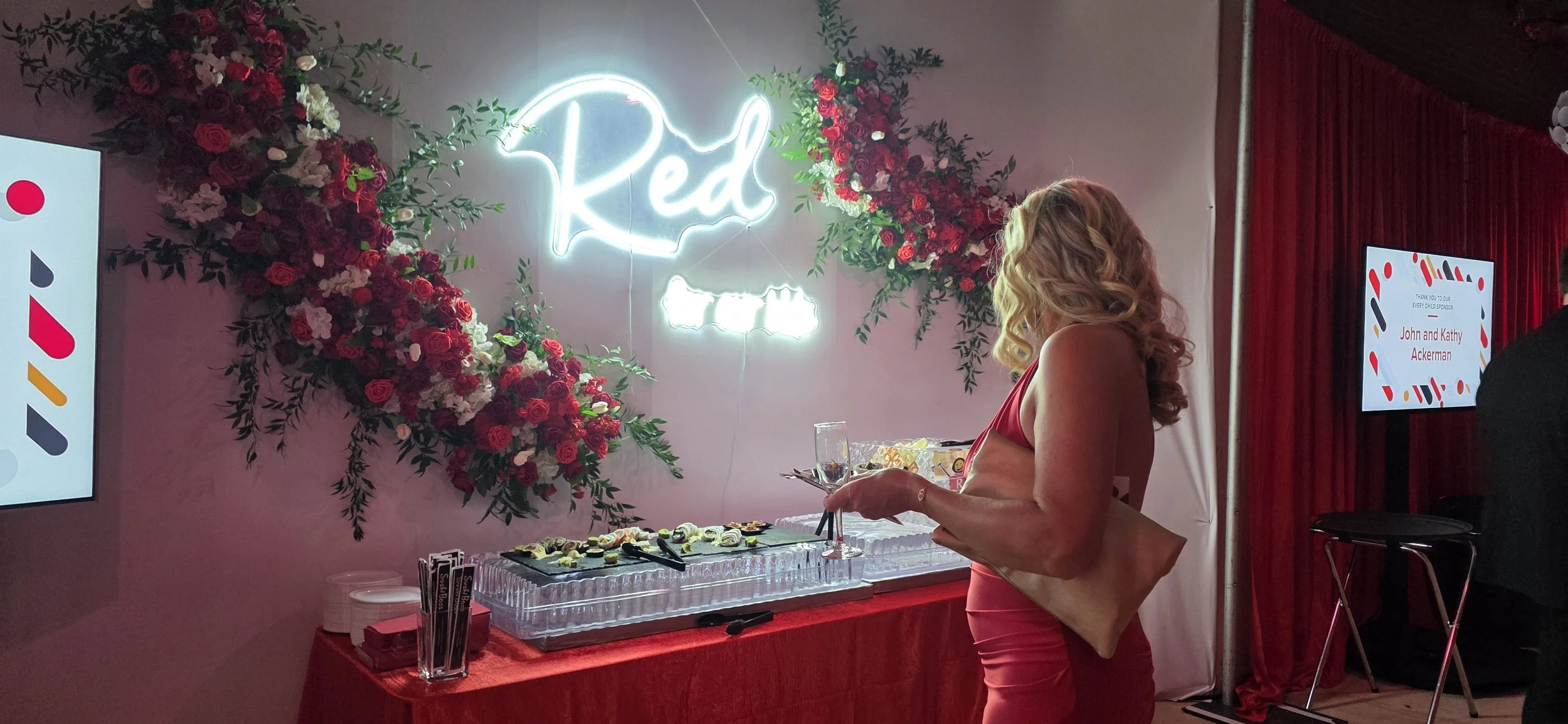 Guest enjoying the dessert presentation at the Riley RED Gala at JPS Events at Regions Tower, featuring chef-driven in-house catering, custom floral backdrops, illuminated neon branding, and full-service event planning in downtown Indy.