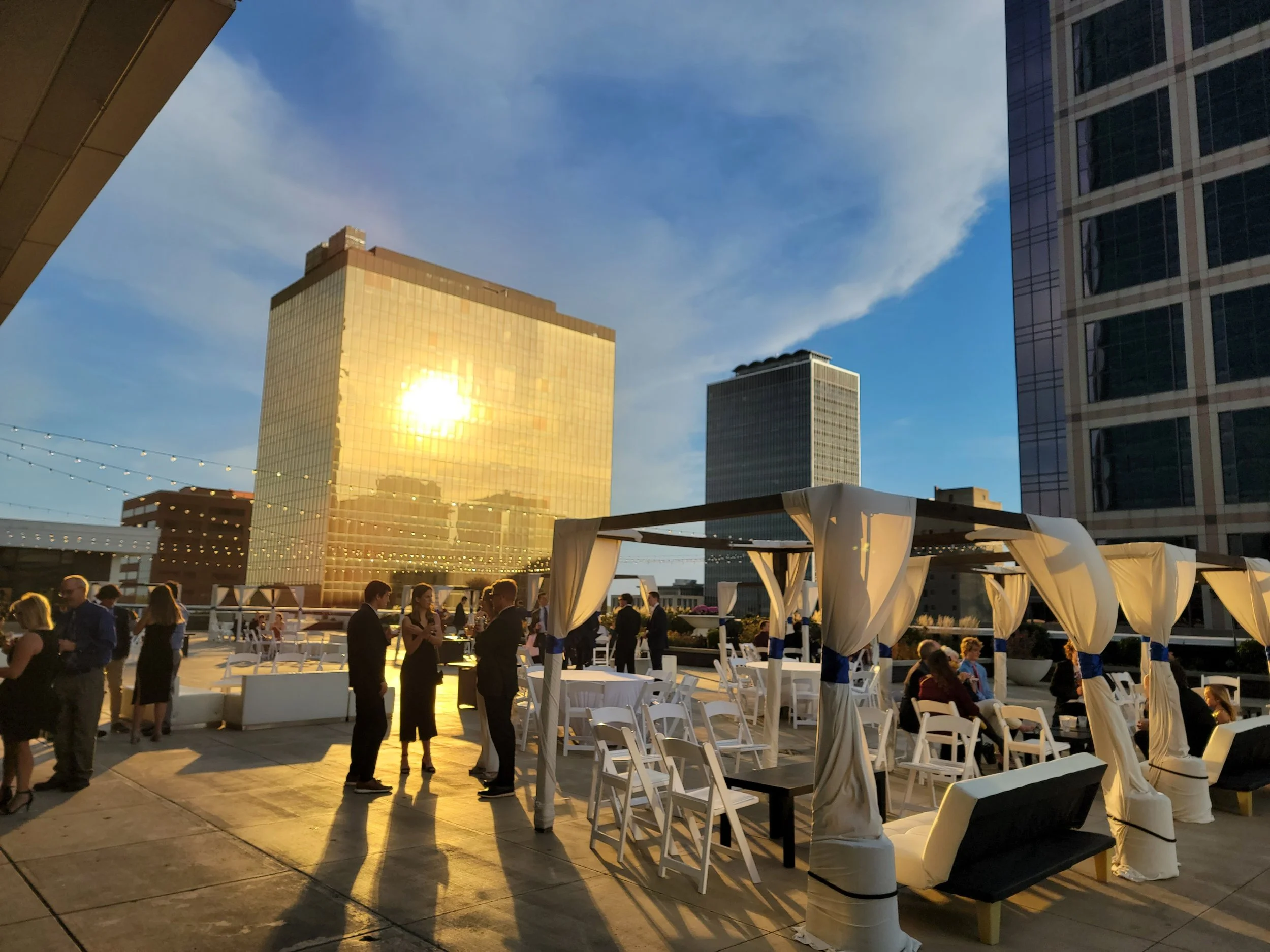 Sunset wedding reception on the 11,000 sq. ft. 5th-floor penthouse terrace at JPS Events at Regions Tower, featuring golden hour photography settings and a seamless transition to the indoor ballroom