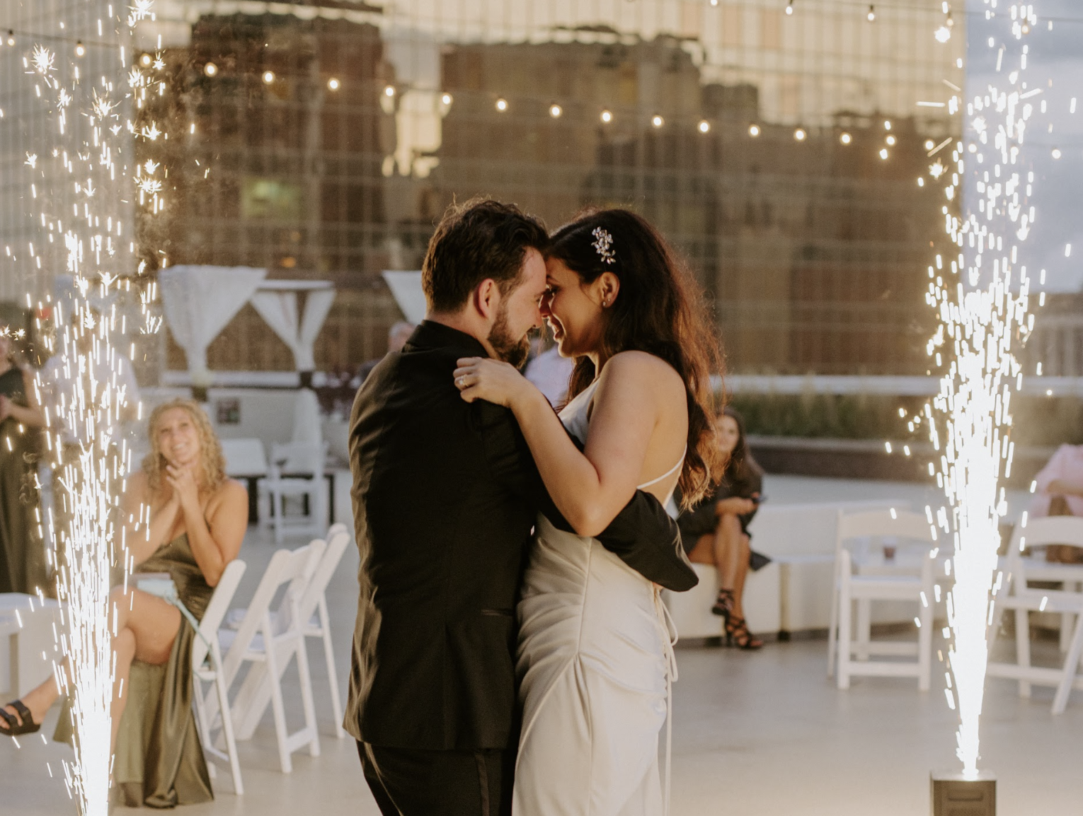 Romantic first dance framed by cold spark pyrotechnics on the 11,000 sq ft penthouse terrace at JPS Events at Regions Tower. Offers high-end production, 360 downtown Indy skyline views, and zero late-out fees.