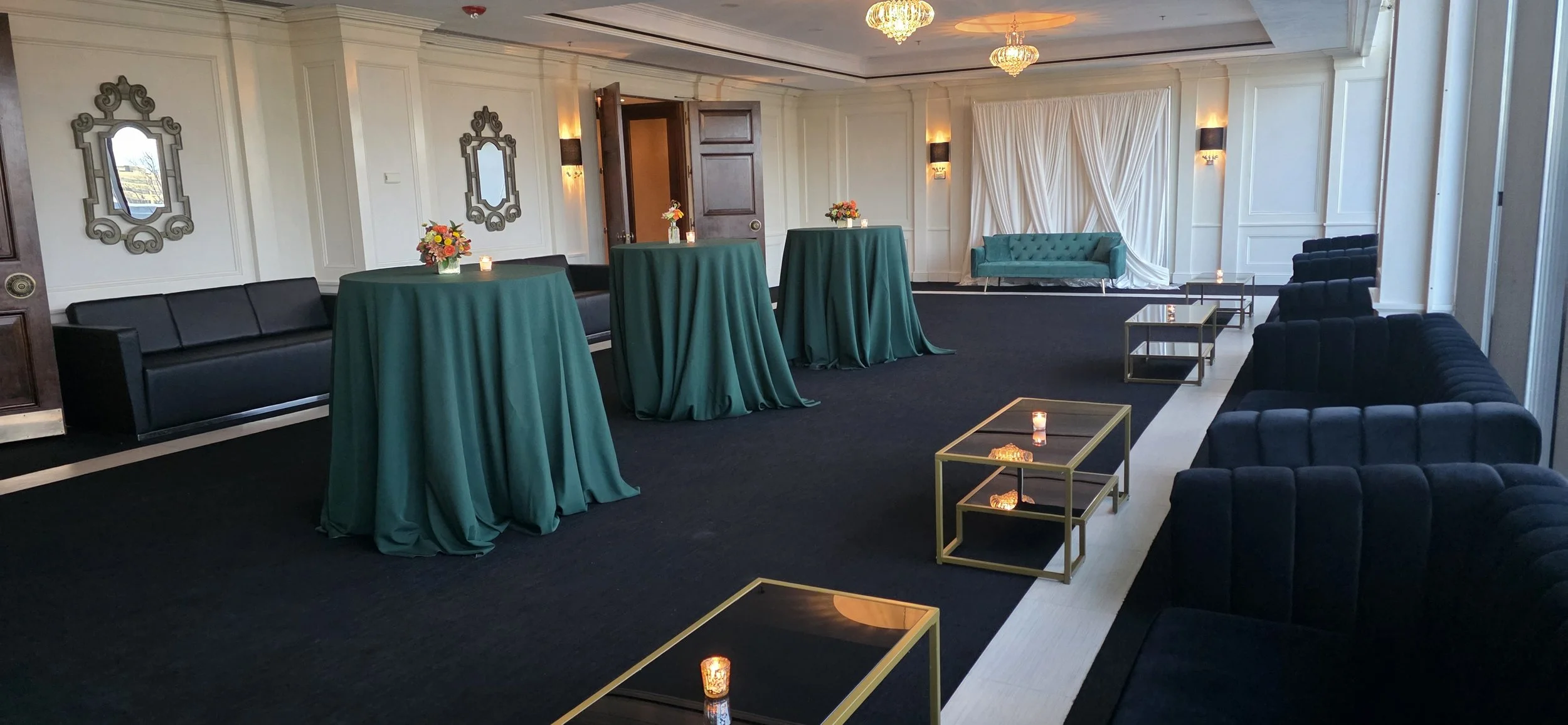 Modern corporate lounge setup at JPS Events at Regions Tower, featuring black velvet sofas, green tablescapes, chef-driven catering, and flexible blank-canvas event space in downtown Indy.