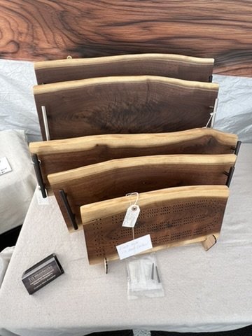 Live edge black walnut charcuterie trays, votive candle holders, and cribbage board. Mt. Horeb Art Fair, July 2026.