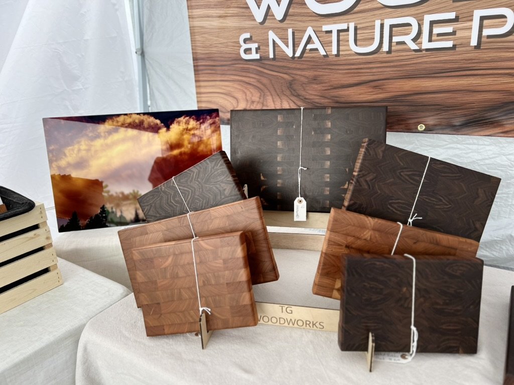 End grain black walnut butcher blocks and unedited metal print of storm clouds. Mt. Horeb Art Fair, July 2026 Mt. Horeb Art Fair, July 2026.