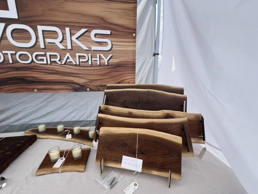 Live edge black walnut charcuterie trays, votive candle holders, and cribbage board. Mt. Horeb Art Fair, July 2026.