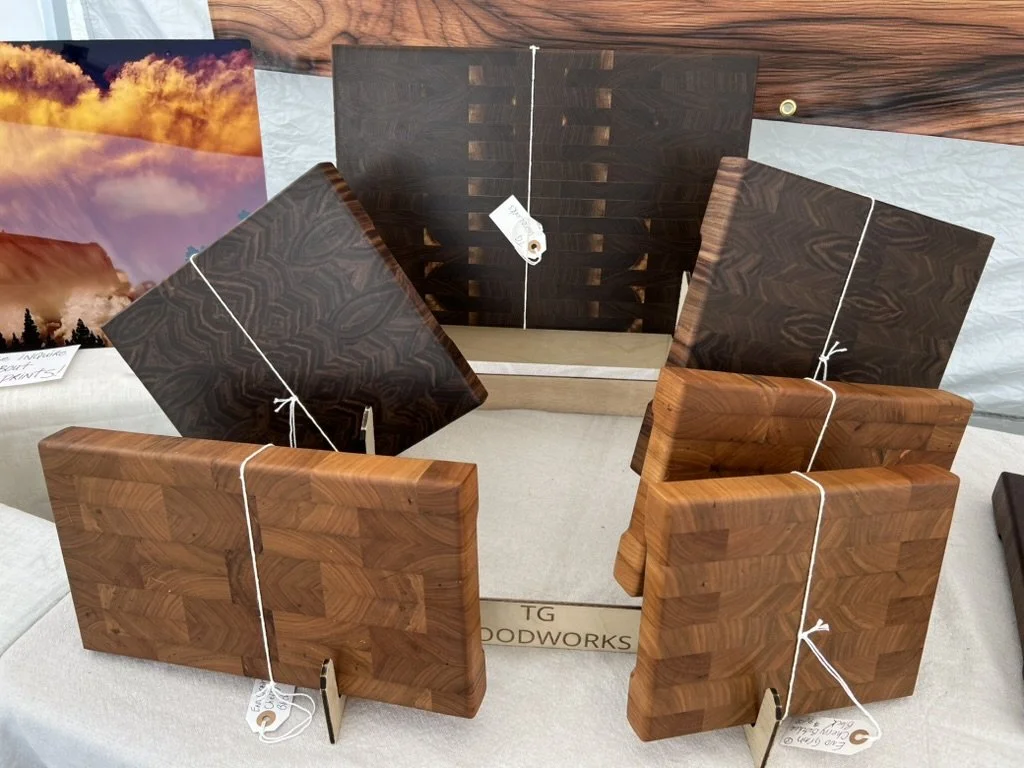 End grain black walnut butcher blocks and unedited metal print of storm clouds. Mt. Horeb Art Fair, July 2026. Mt. Horeb Art Fair, July 2026.