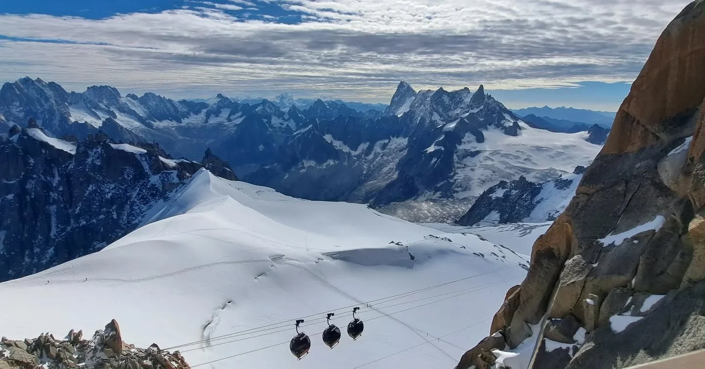 One of the rare clear days this summer at the #aiguilledumidi overlooking the #grandjorasse peak. The peak on the left side is France and on the right side Italy. The red bubbles below are called 'Le Panoramic' is how we traverse into Italy from Fran