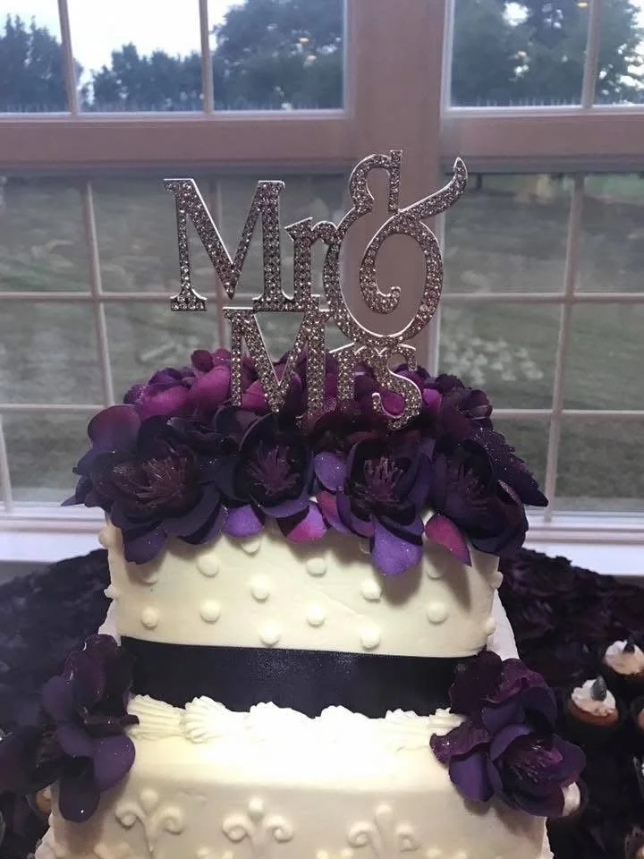 White birthday cake decorated with purple flowers and a 