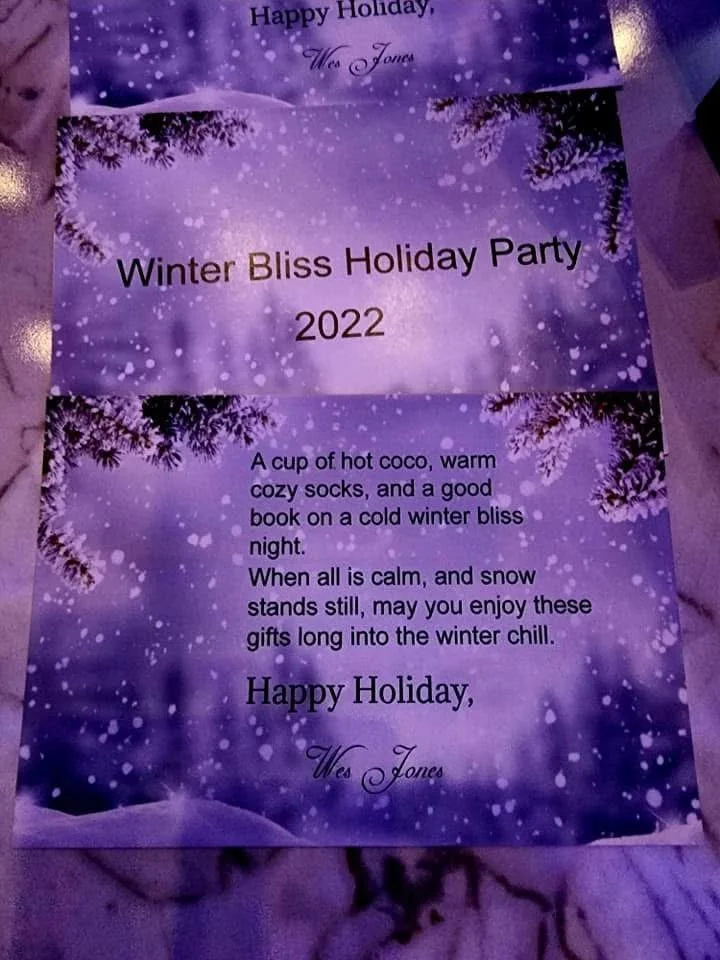 A festive purple holiday card with snowy winter scenes and pine branches. The card contains a poem wishing warm, cozy holiday gifts.