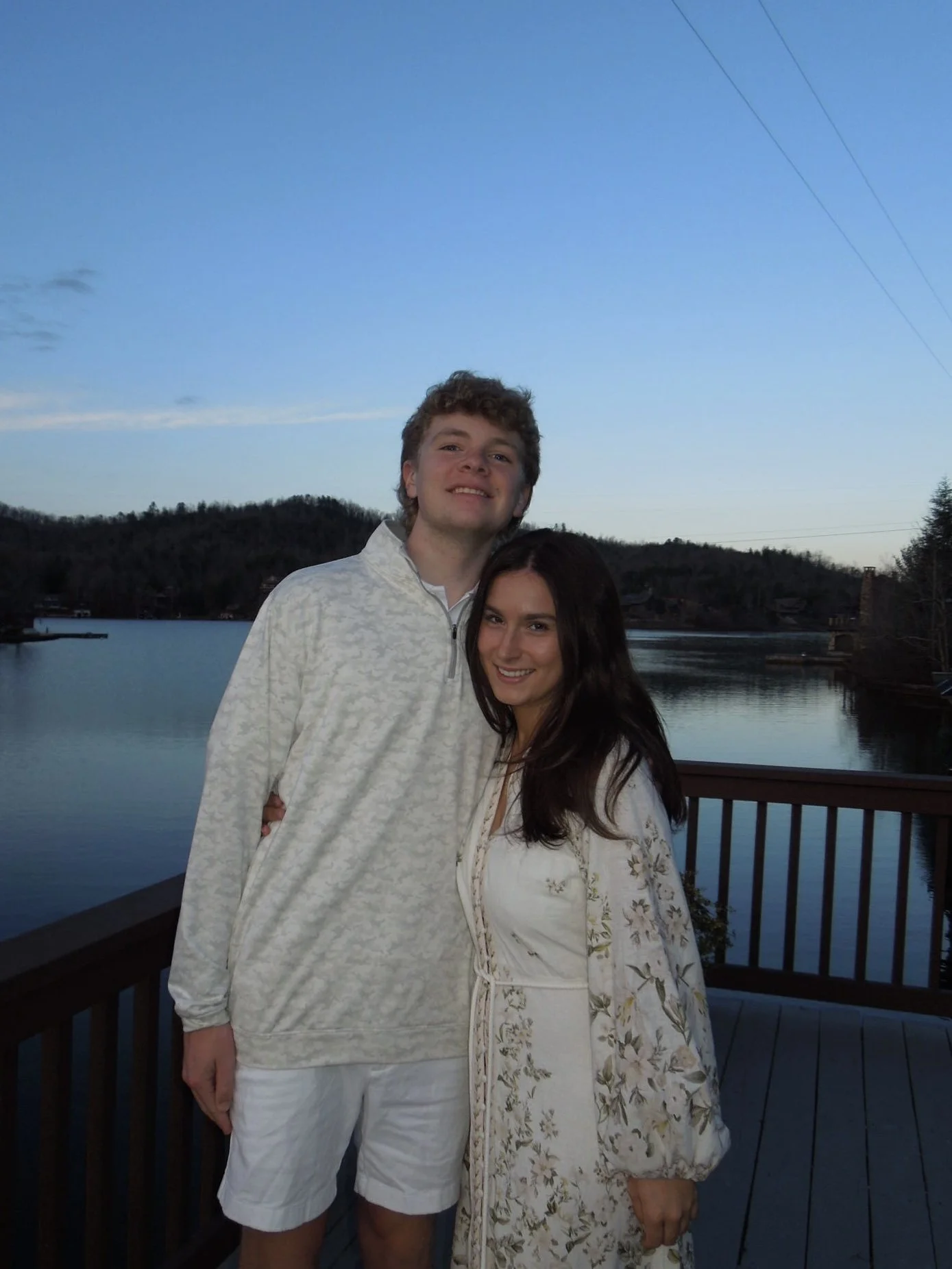 A young couple enjoying a sunset on a wooden deck, reflecting The Fold’s philosophy of restoration and nature-inspired home wellness.