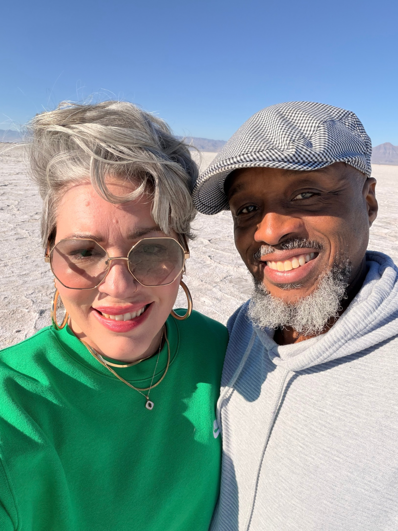 Gen X travel content creator couple Marie and Tony Morgan smiling together in an outdoor lifestyle setting