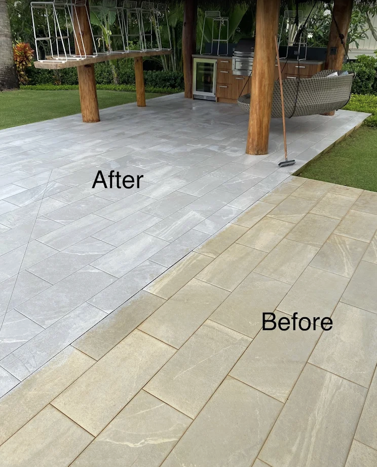 Transition from a beige tiled patio area to a gray tiled patio area in an outdoor setting, with a grill and outdoor furniture under a wooden pergola.