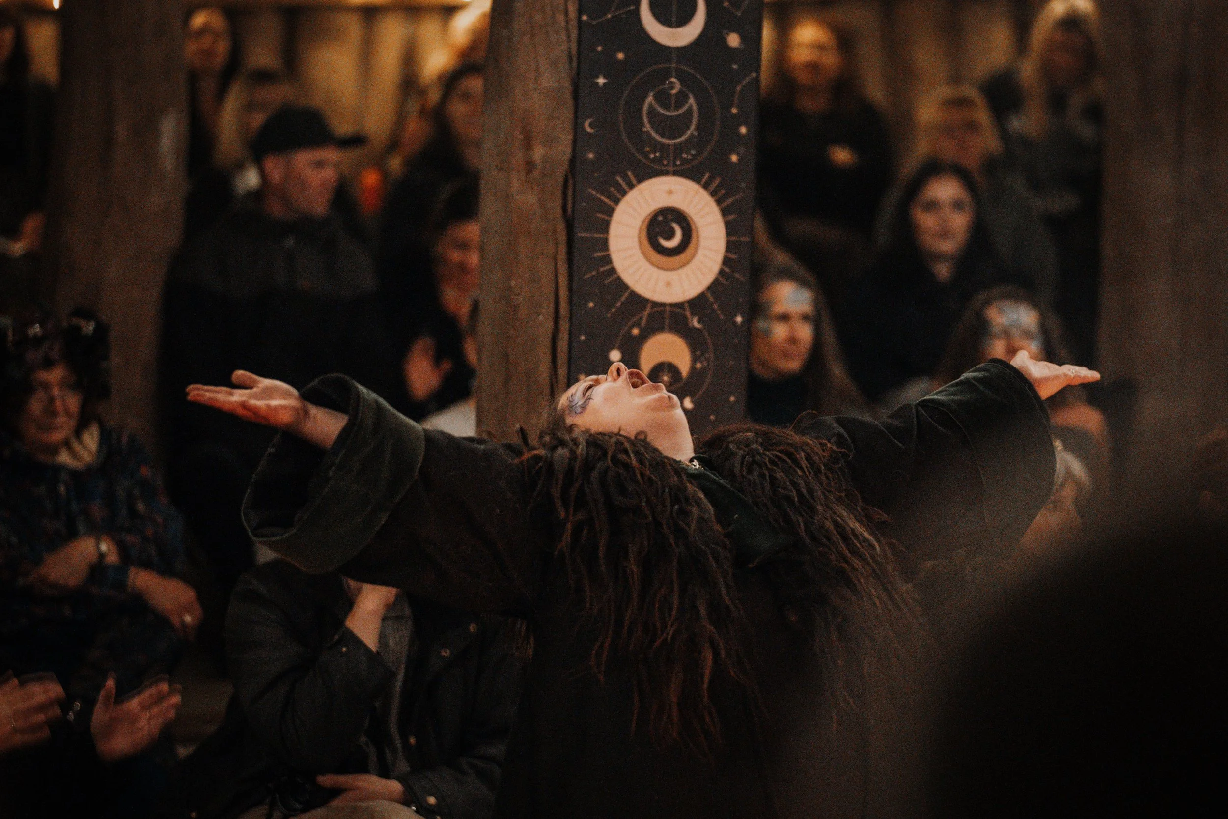 An image of the fabulous Ellie Brooks in her Element during the Samhain 2025 Earthkin Event. Her arms are spread wide as she shouts up to the sky.