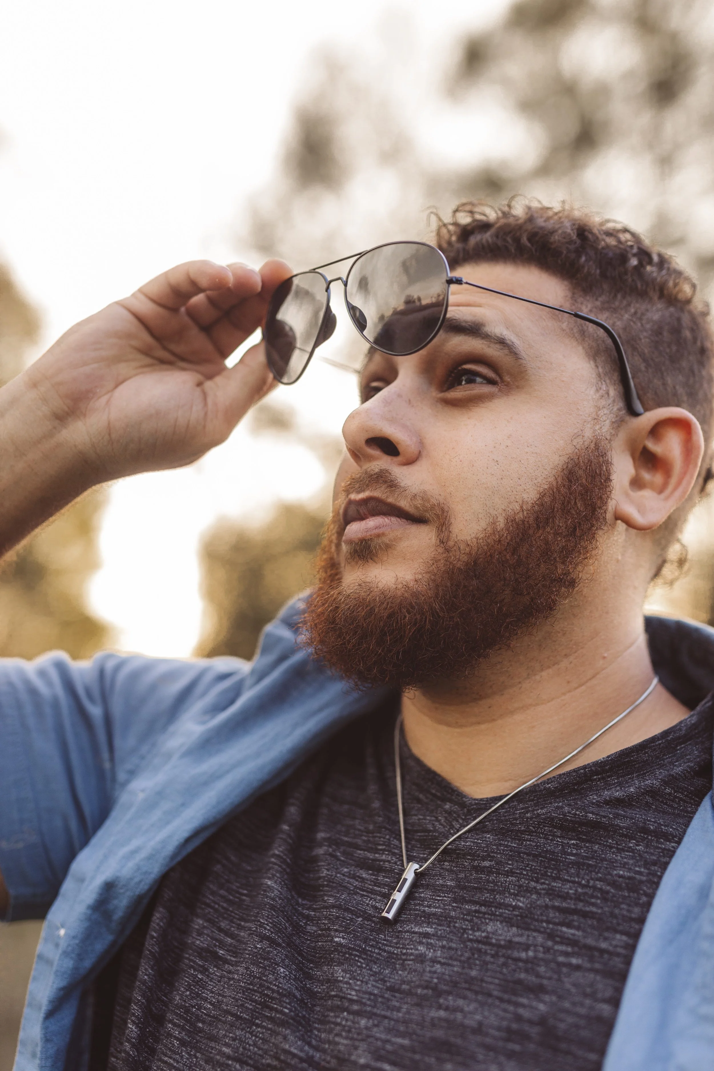 Wali Evers, co-founder of Evers & Co. Media, adjusting his aviator sunglasses during an outdoor portrait