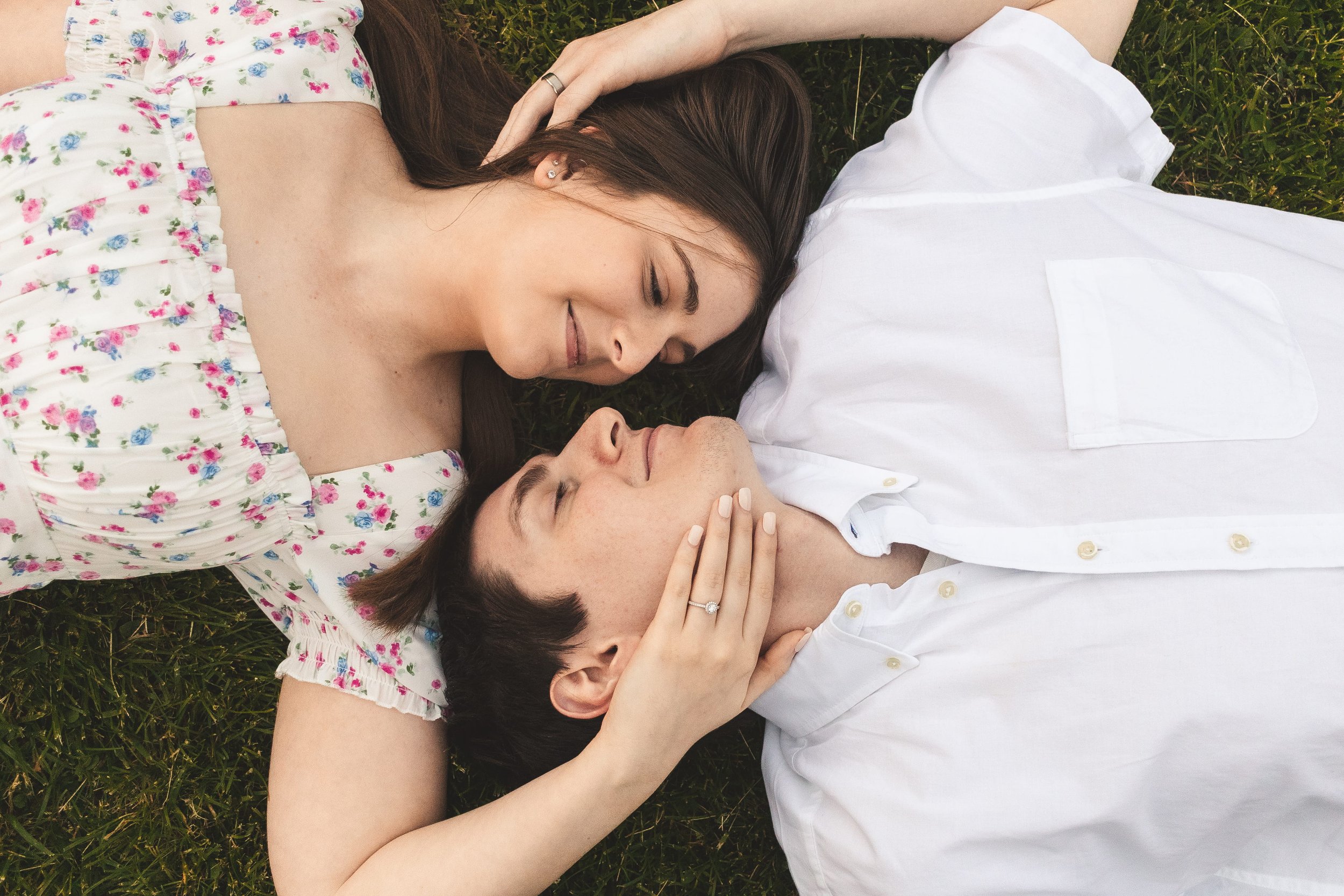 Couple lying together on green grass, overhead portrait photography by Evers & Co. Media