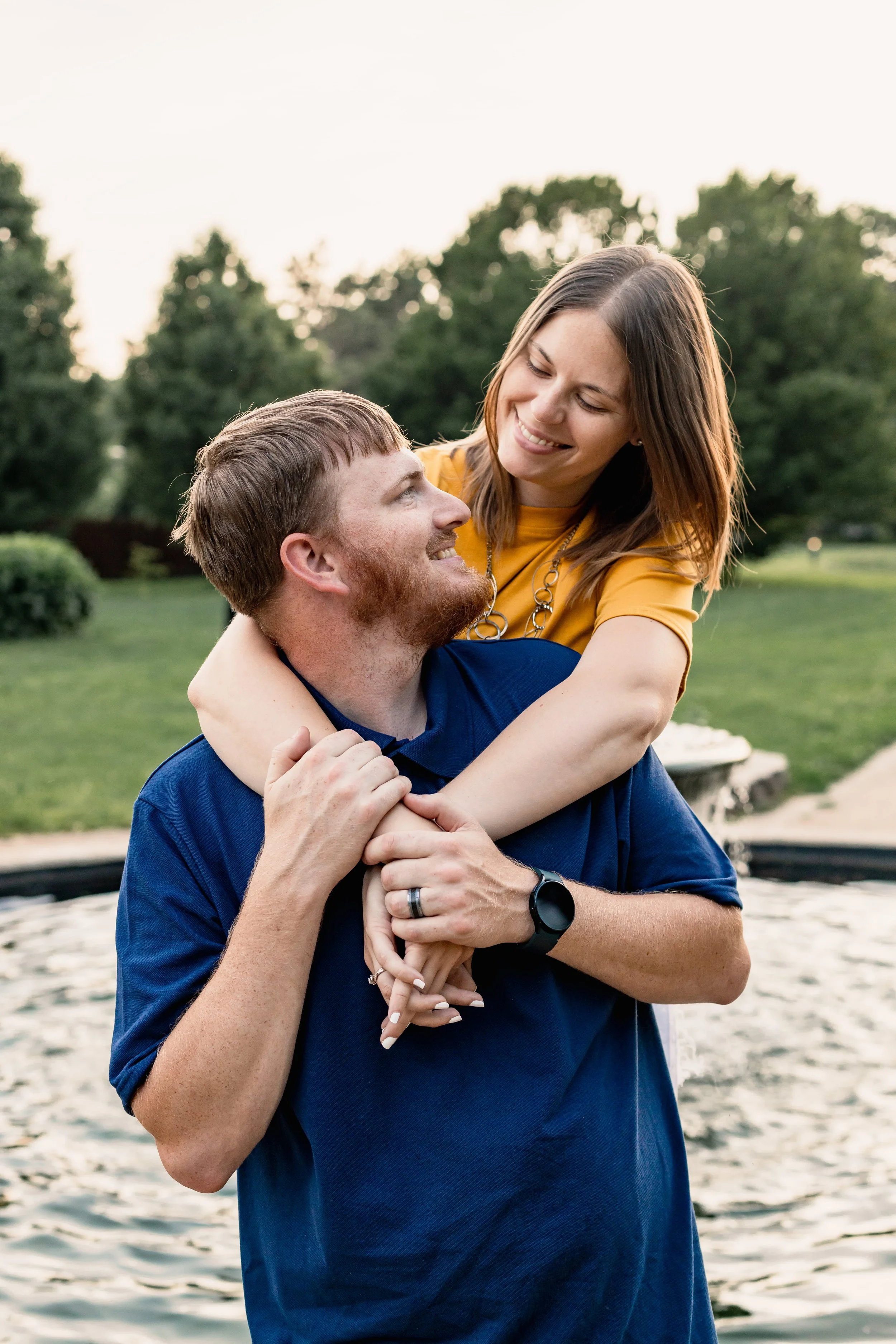 Couple embracing in a park, man in navy shirt and woman in yellow dress, lifestyle couples portrait