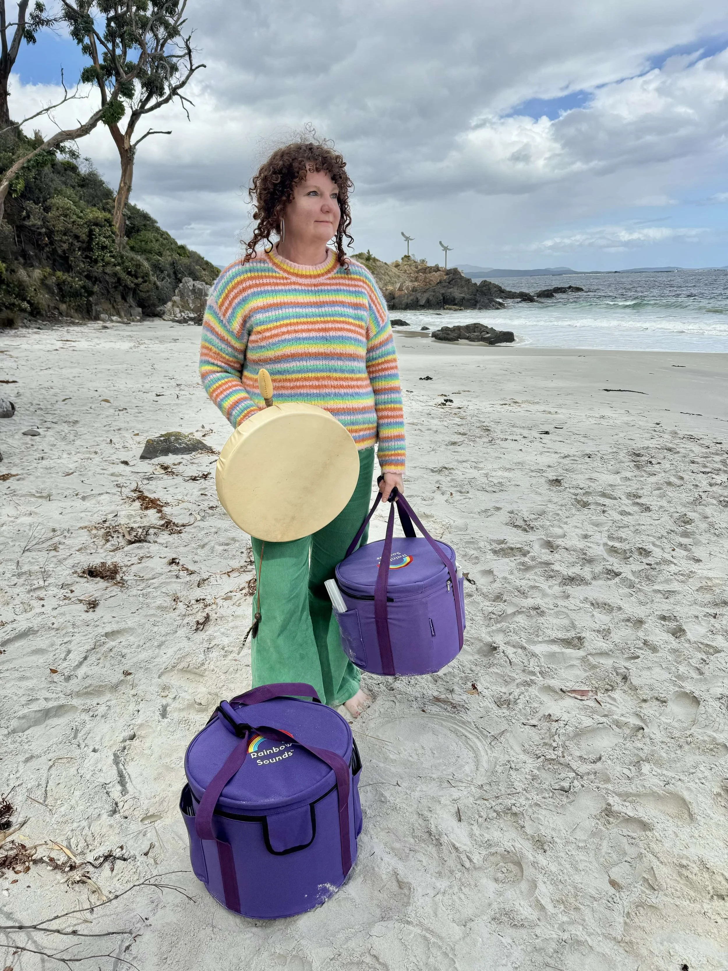 Sound healing practitioner with instruments on a beach in Hobart, Tasmania