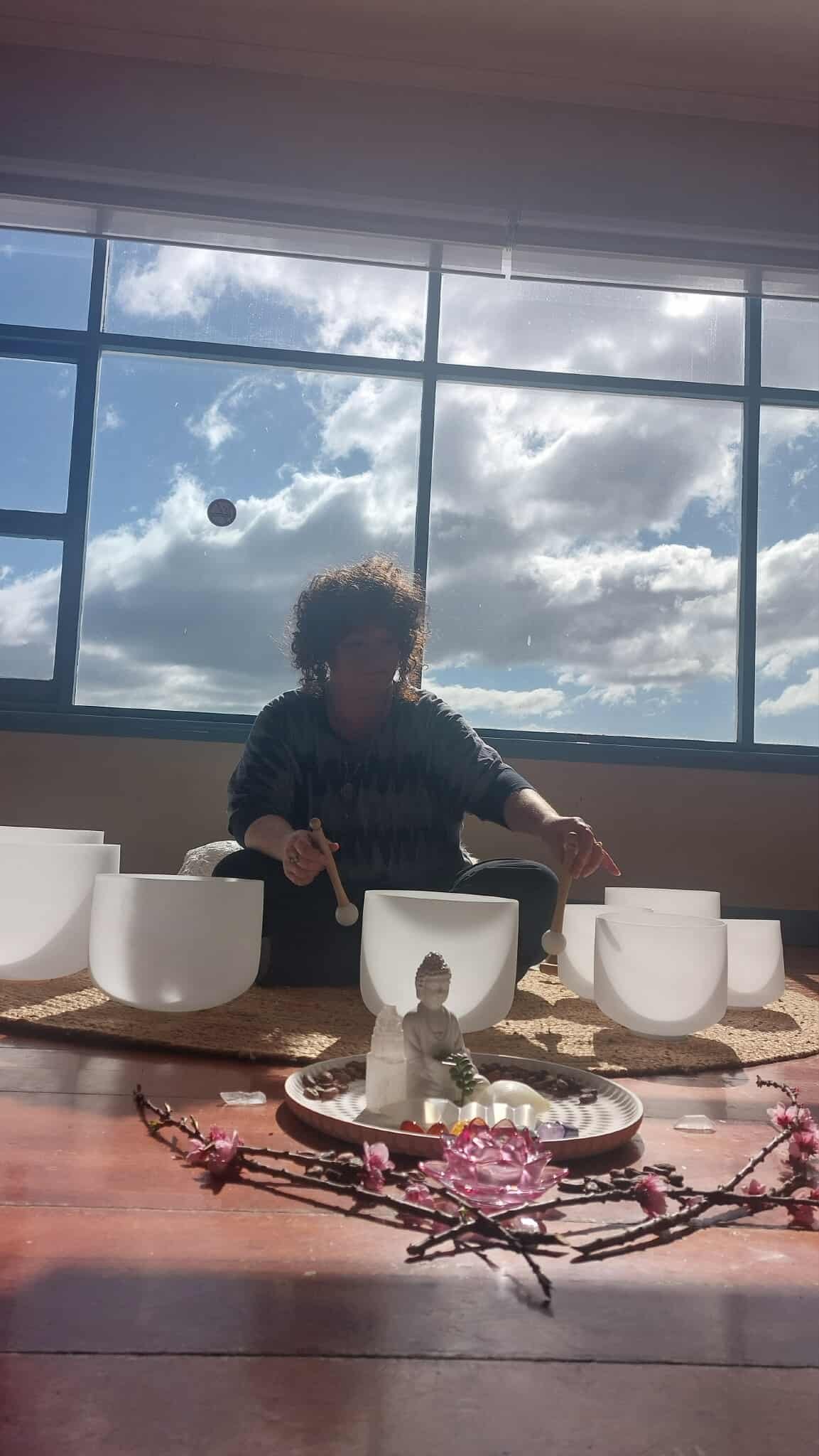 Sound therapy practitioner playing crystal singing bowls during a session in Hobart and the Huon Valley