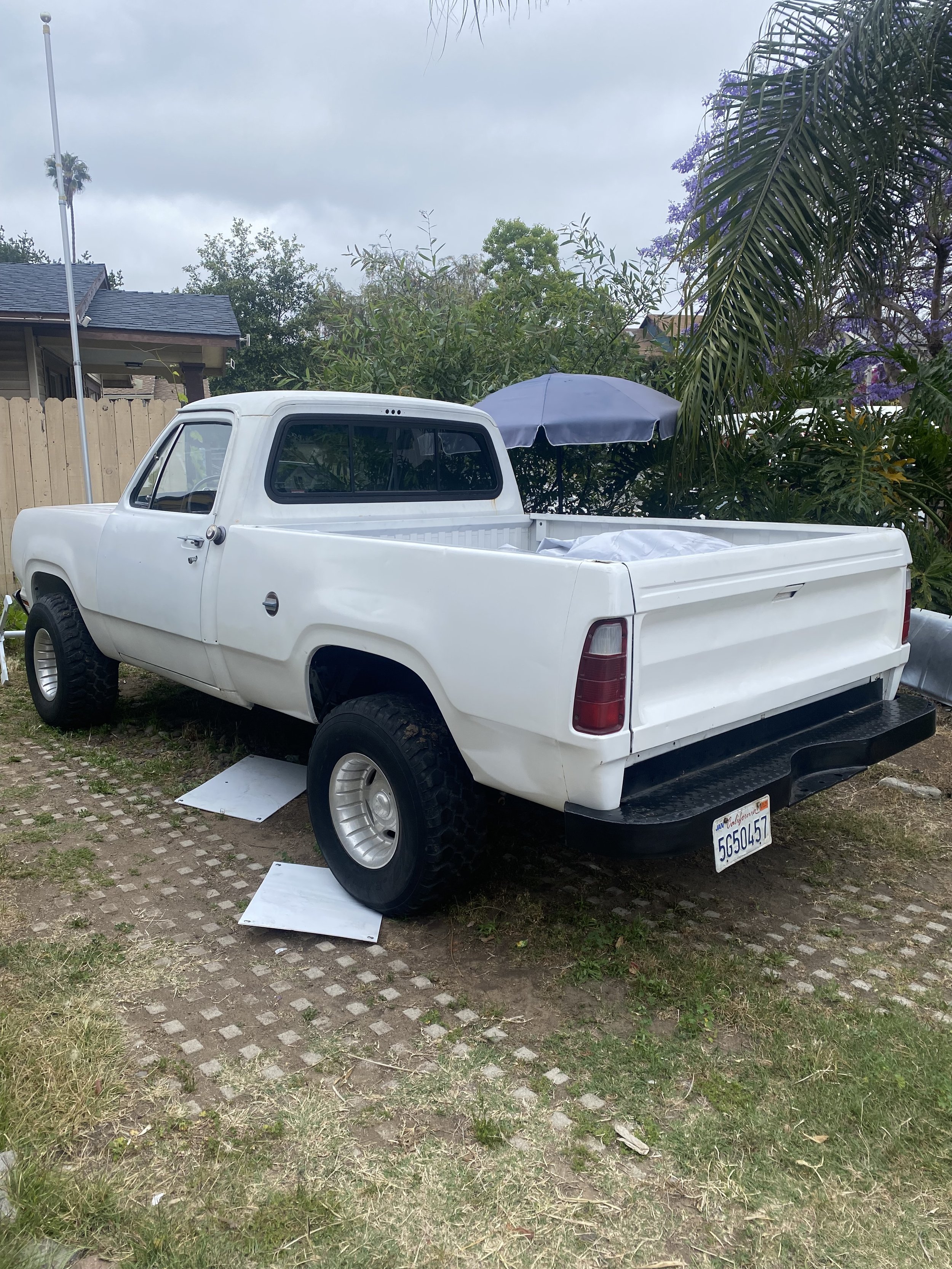 Rear view of restored Dodge W100 pickup truck with newly painted bed and tailgate.
