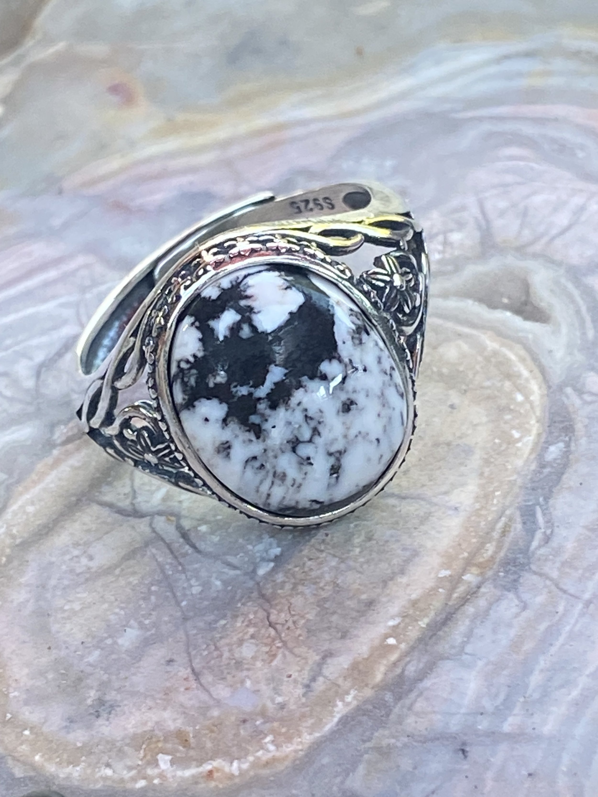 Natural White Buffalo turquoise ring with striking black and white patterns set in an engraved sterling silver setting.
