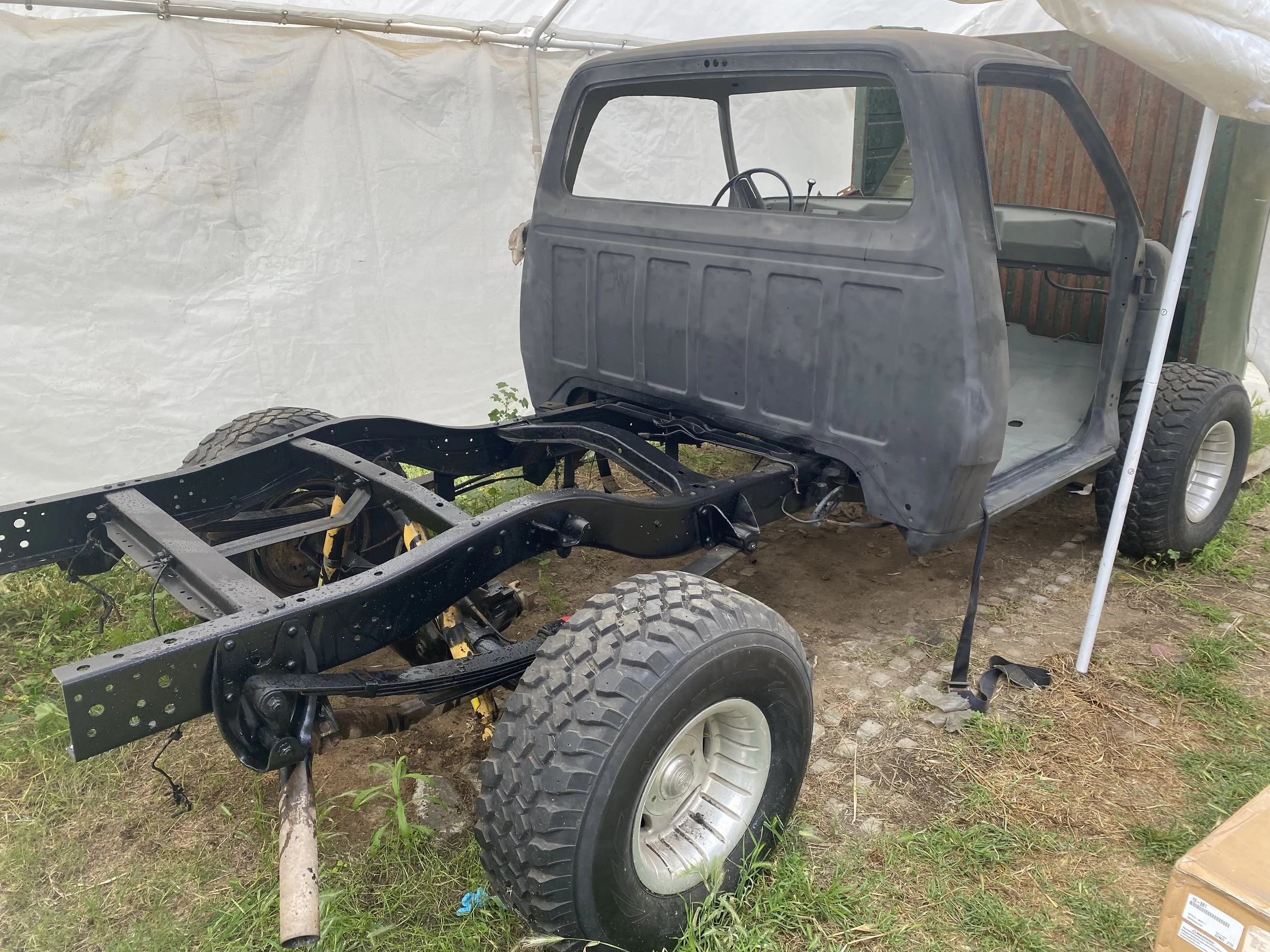 1976 Dodge W100 cab separated from the truck bed during frame-off restoration, exposing the rebuilt chassis and suspension.