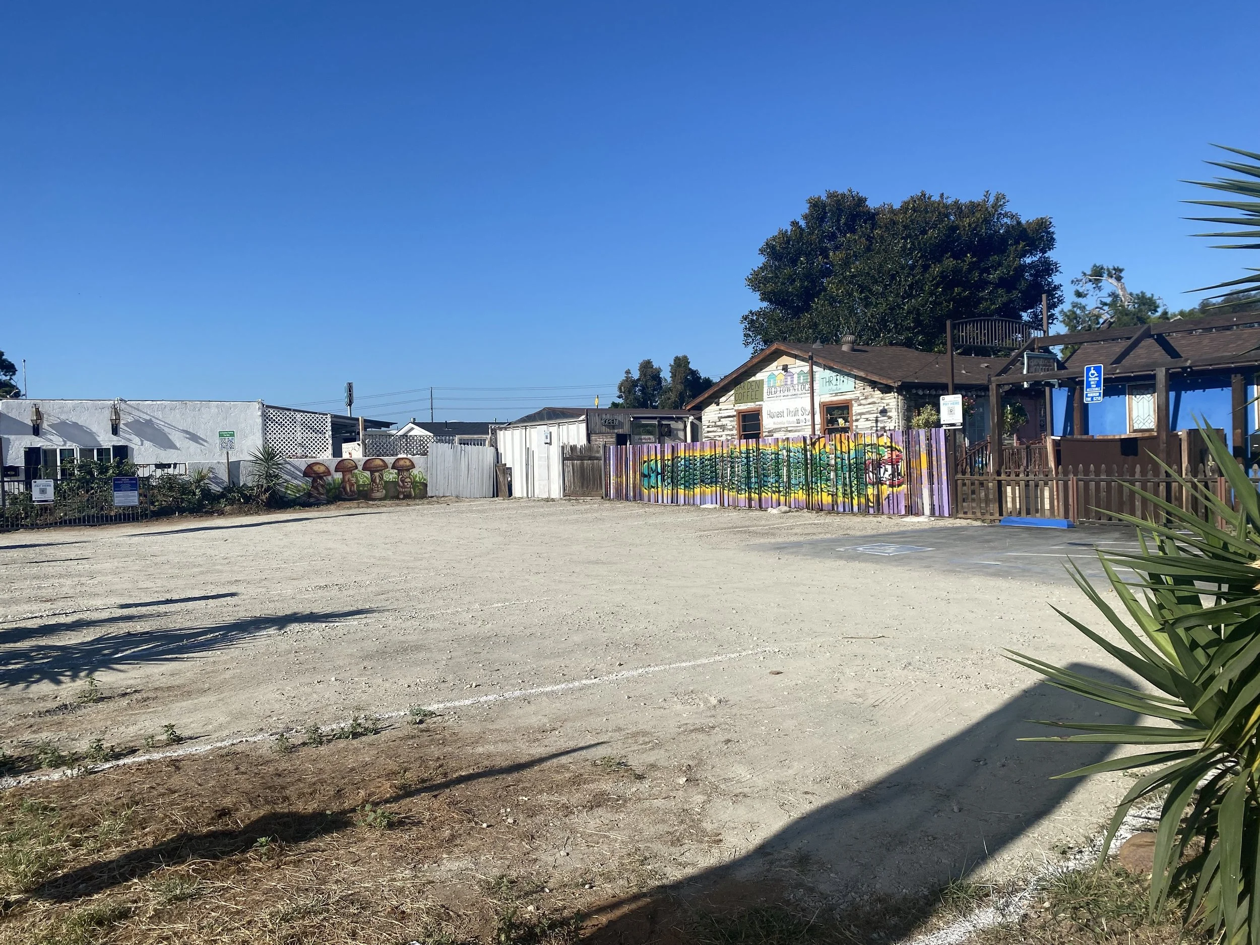 La Esquinas parking lot in Old Town San Diego featuring El Dragón Cambiante and The Watchful Four murals by Memuco, showcasing public art, local culture, and the historic corner at Congress and Twiggs Street.