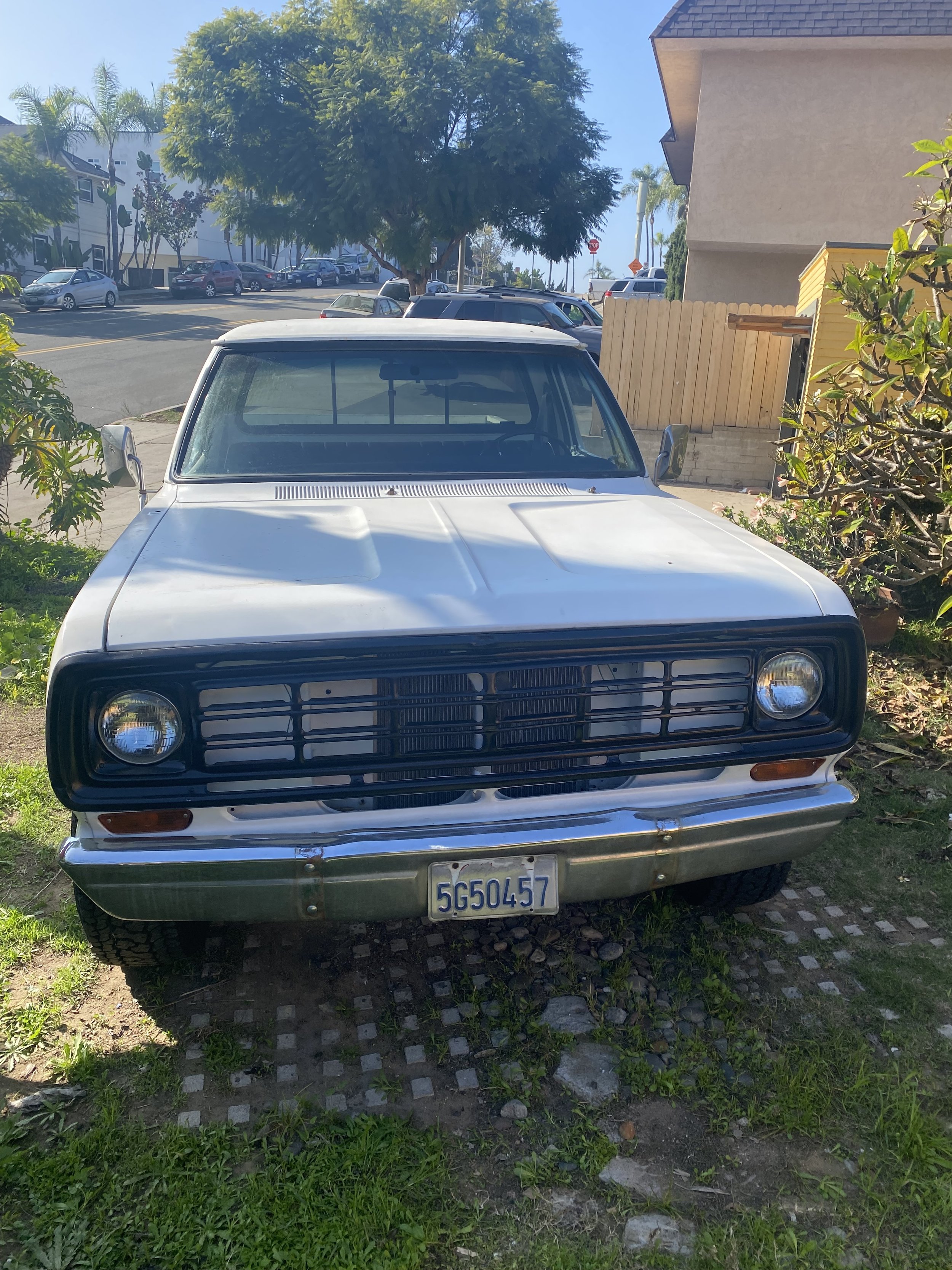 Front view of restored 1976 Dodge W100 showing grille, headlights, and completed restoration.