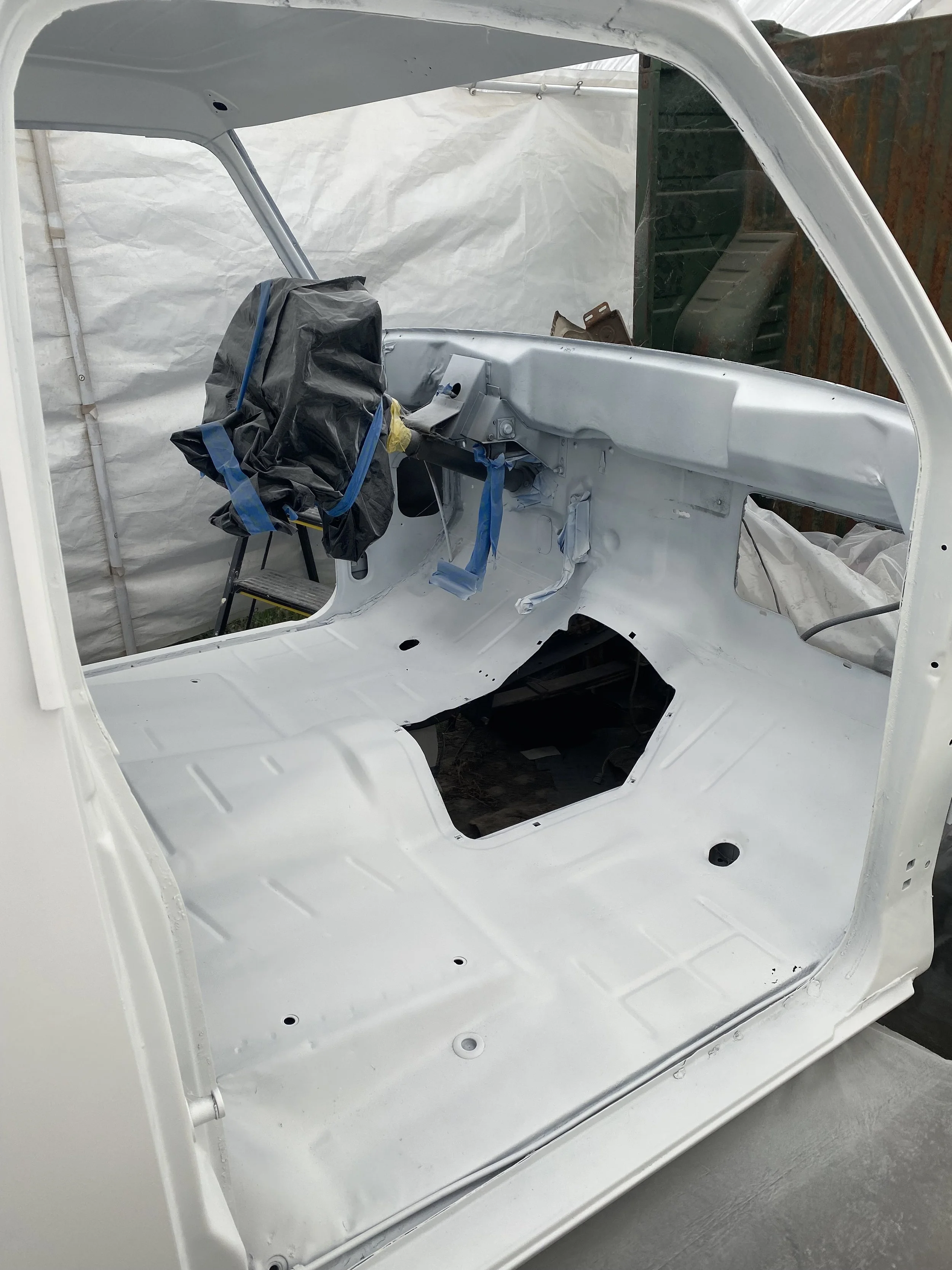 Newly painted interior floor and cab structure of the Dodge W100 during restoration before reassembly.