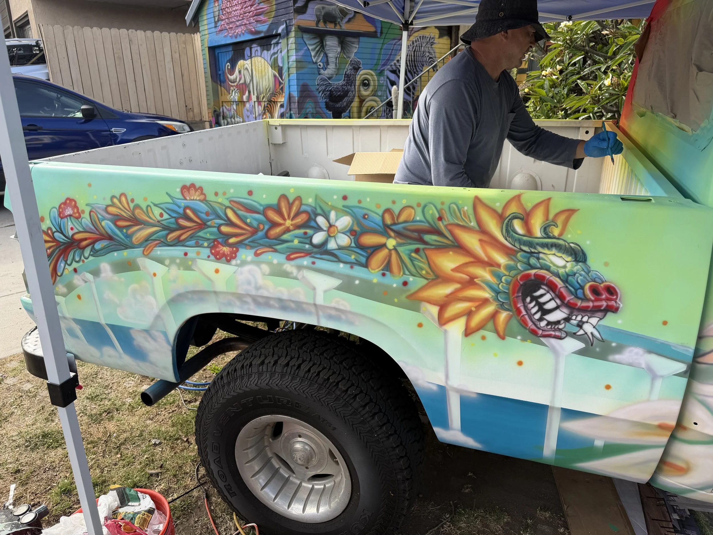 Artist Memuco painting the El Dragón Cambiante mural at La Esquinas in Old Town San Diego.