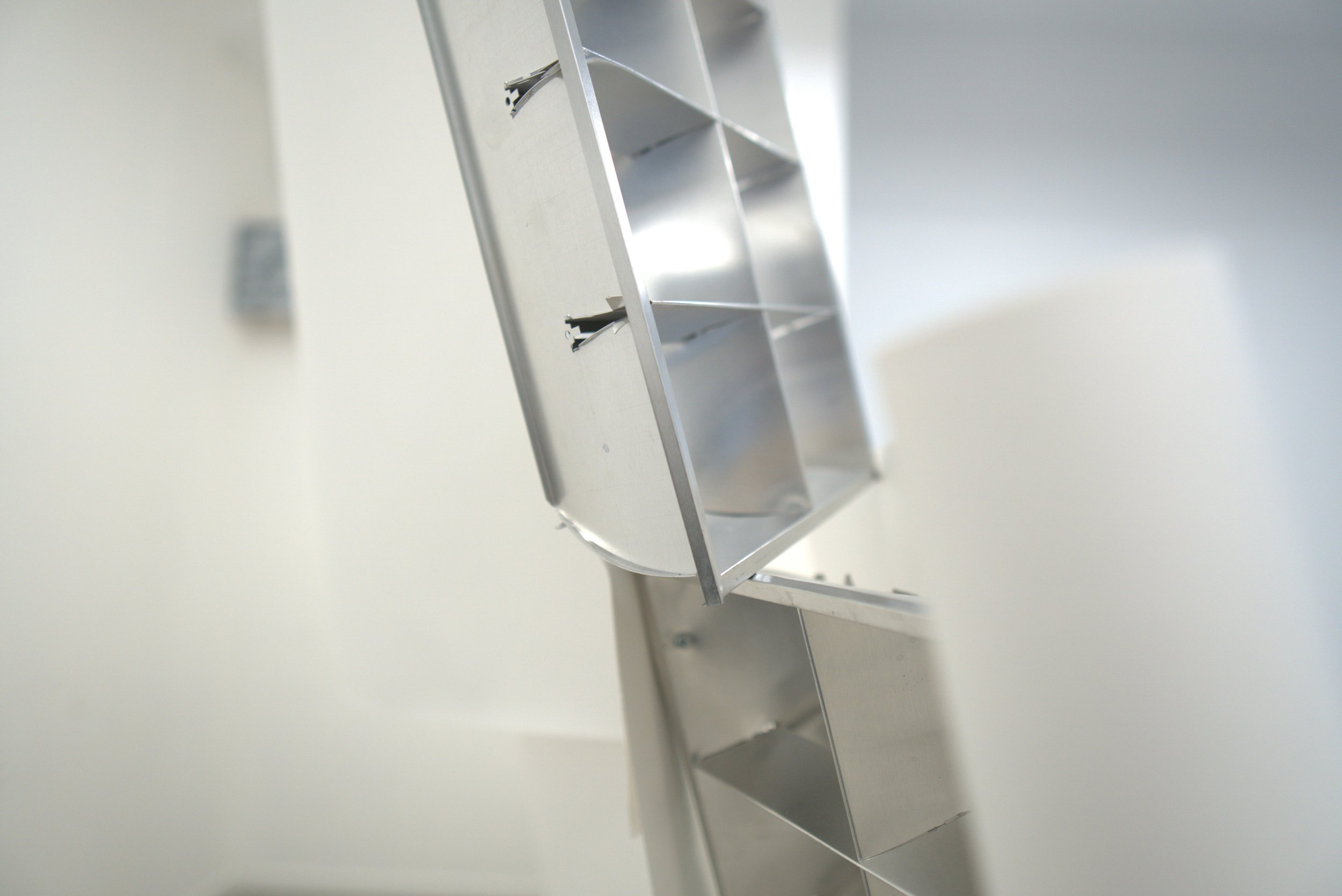 Una estructura de metal en forma de caja con compartimentos internos, probablemente parte de un mobiliario o equipo de almacenamiento.