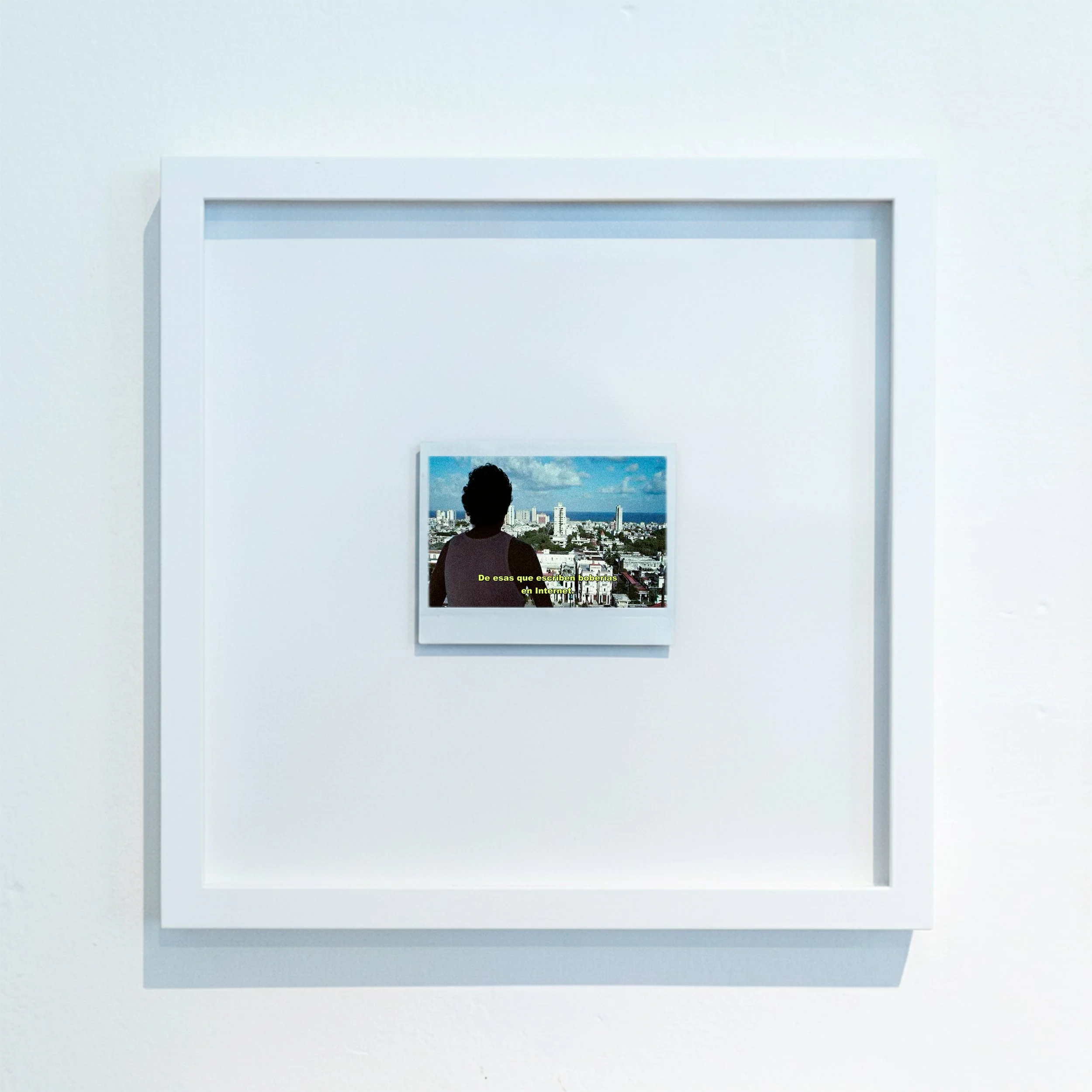 Cuadro blanco con imagen de una ciudad vista de espaldas y texto en español.