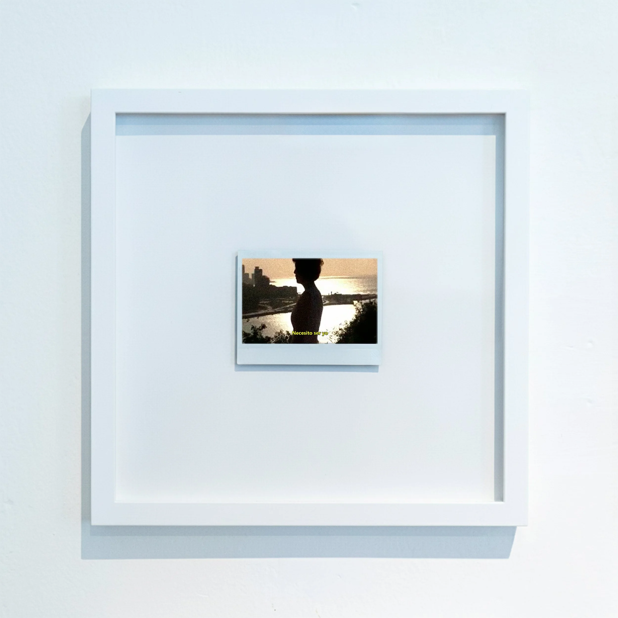 Pantalla de un dispositivo blanco con una imagen de un niño en silhouette junto a un río al atardecer. Texto en amarillo que dice 'Necesito ser yo'.