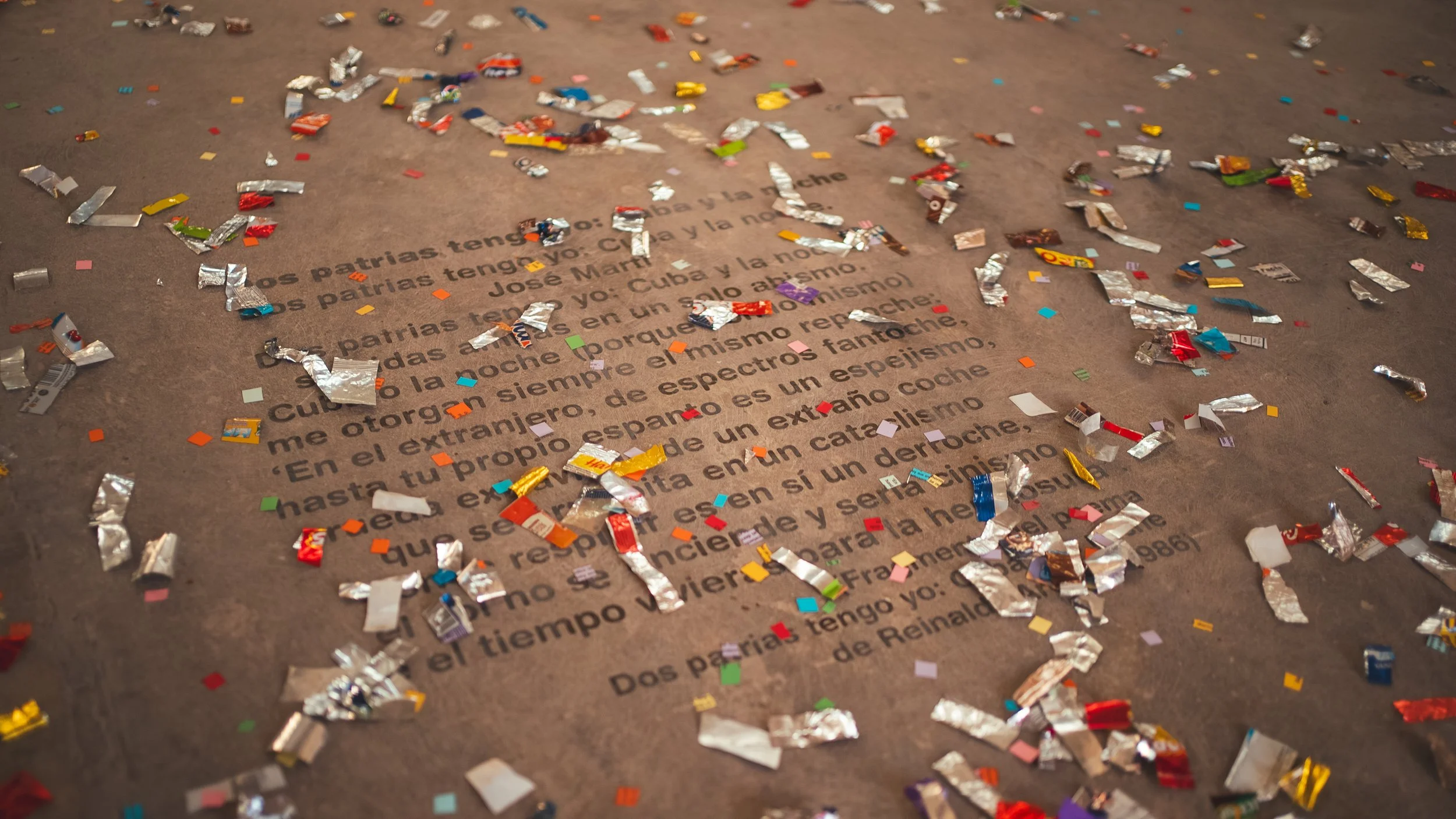 Texto en un papel cubierto de confeti de colores y papel de aluminio festivo.
