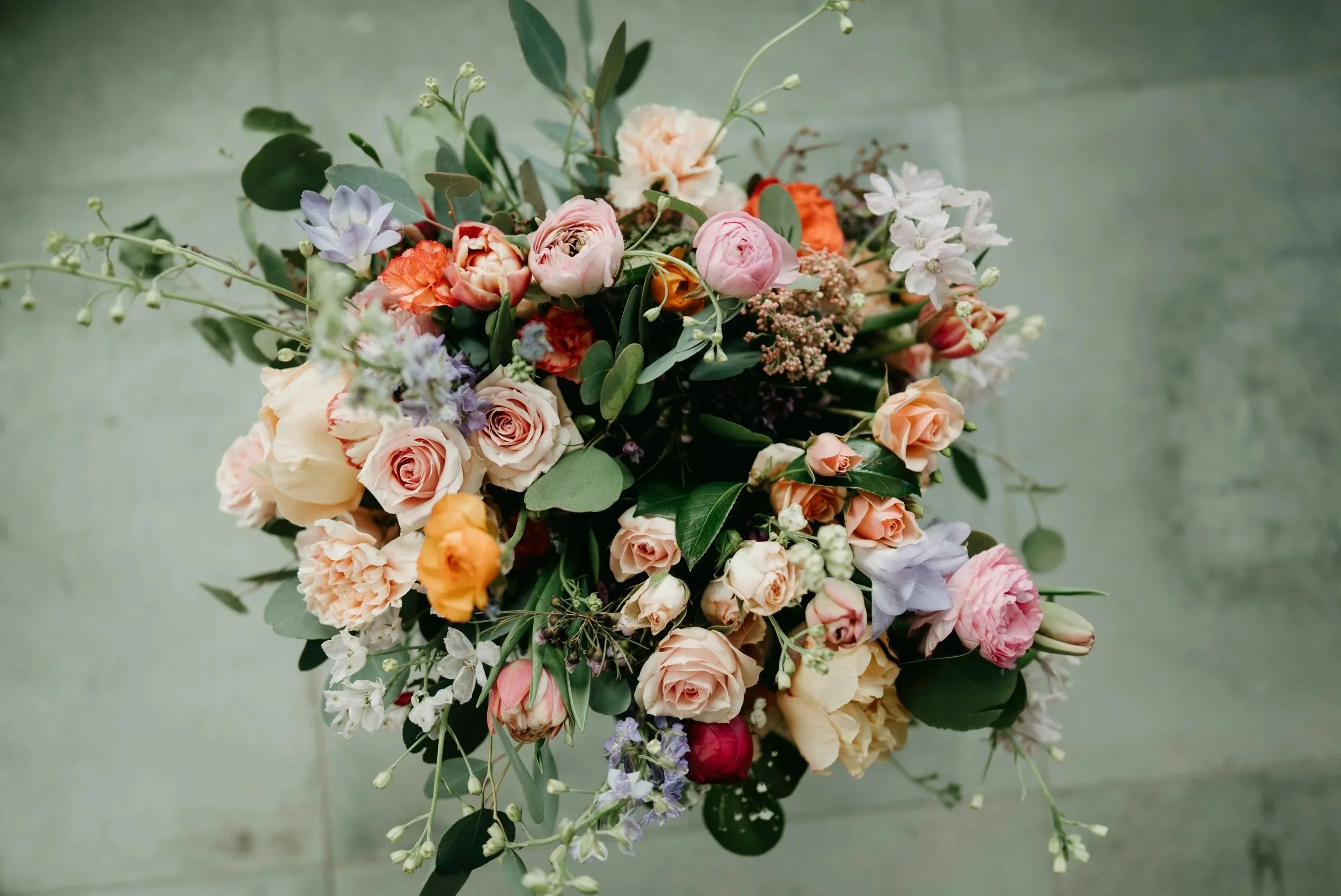A colorful, elegant arrangement of various fresh flowers and greenery.