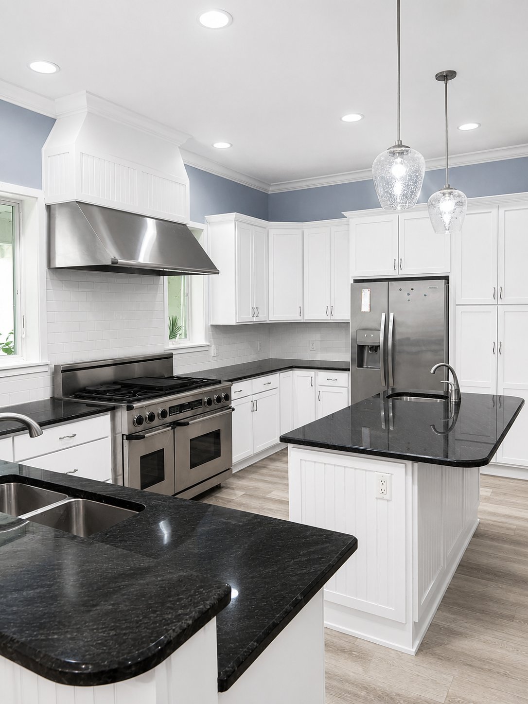 White refinished kitchen cabinets with an island and dark countertops
