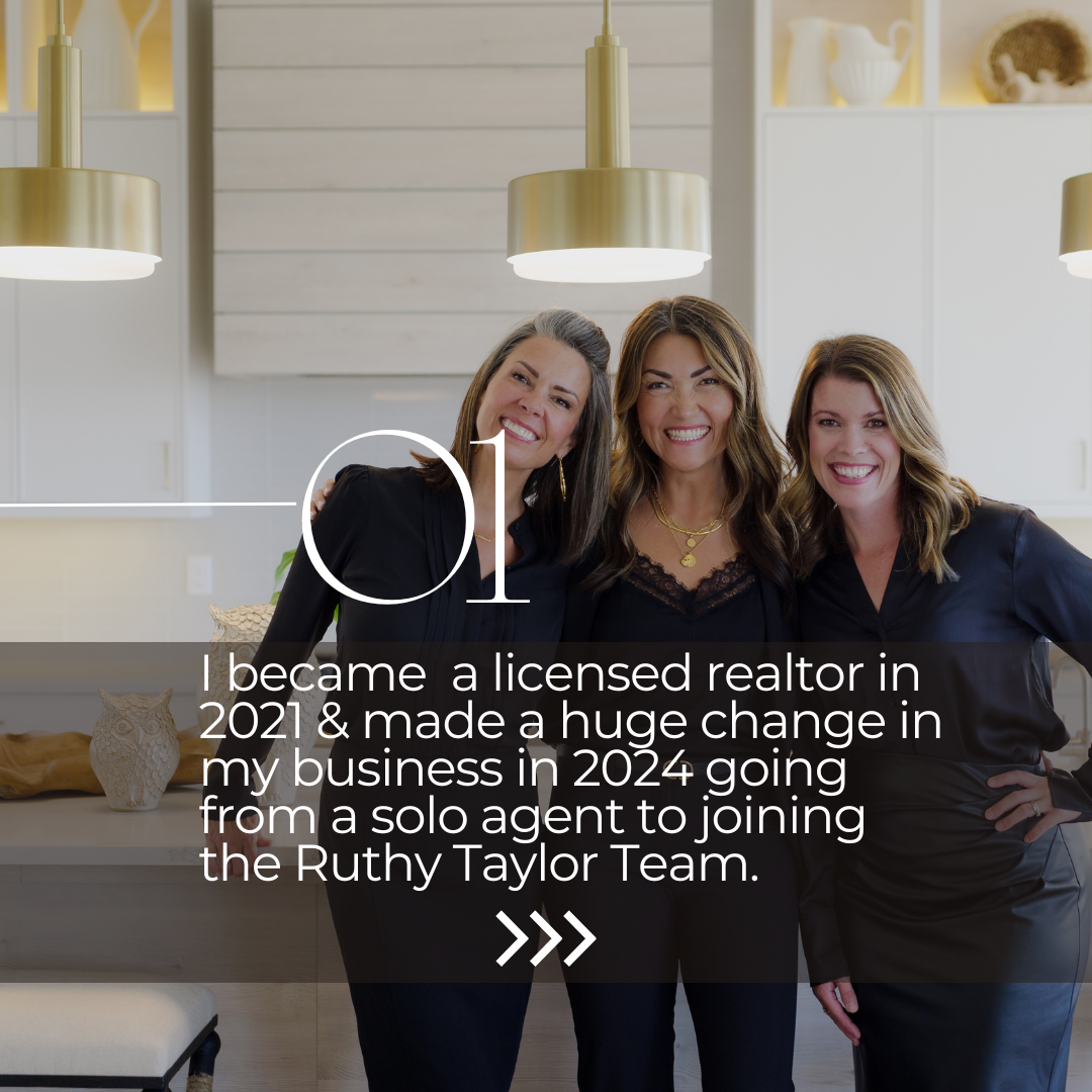 Three smiling women in black outfits standing in a modern kitchen with hanging lights and white cabinets.