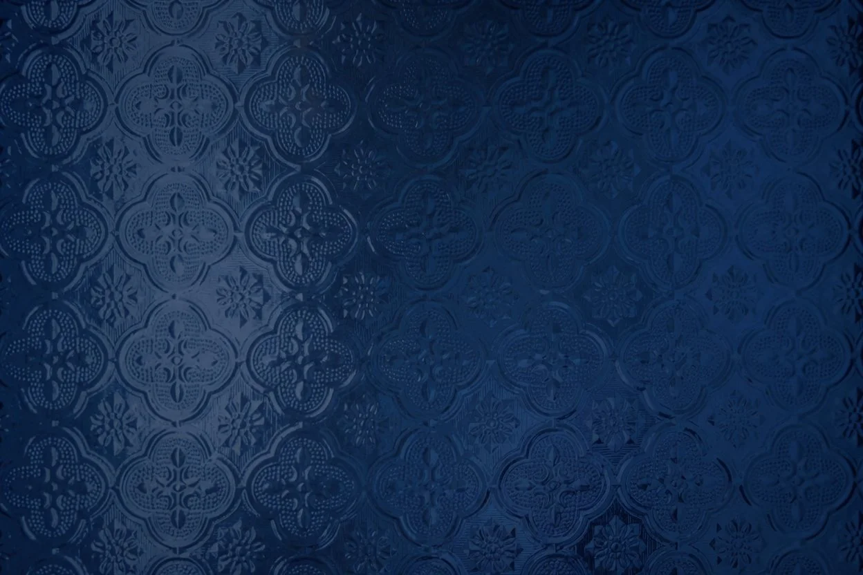 Close-up of a dark blue textured surface with geometric and floral patterns.
