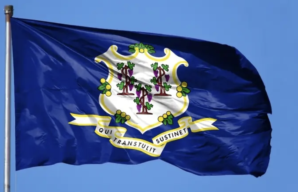 The flag of Connecticut, featuring a blue background with the state's coat of arms in the center and the motto 'Qui Transtulit Sustinet' on a ribbon below.