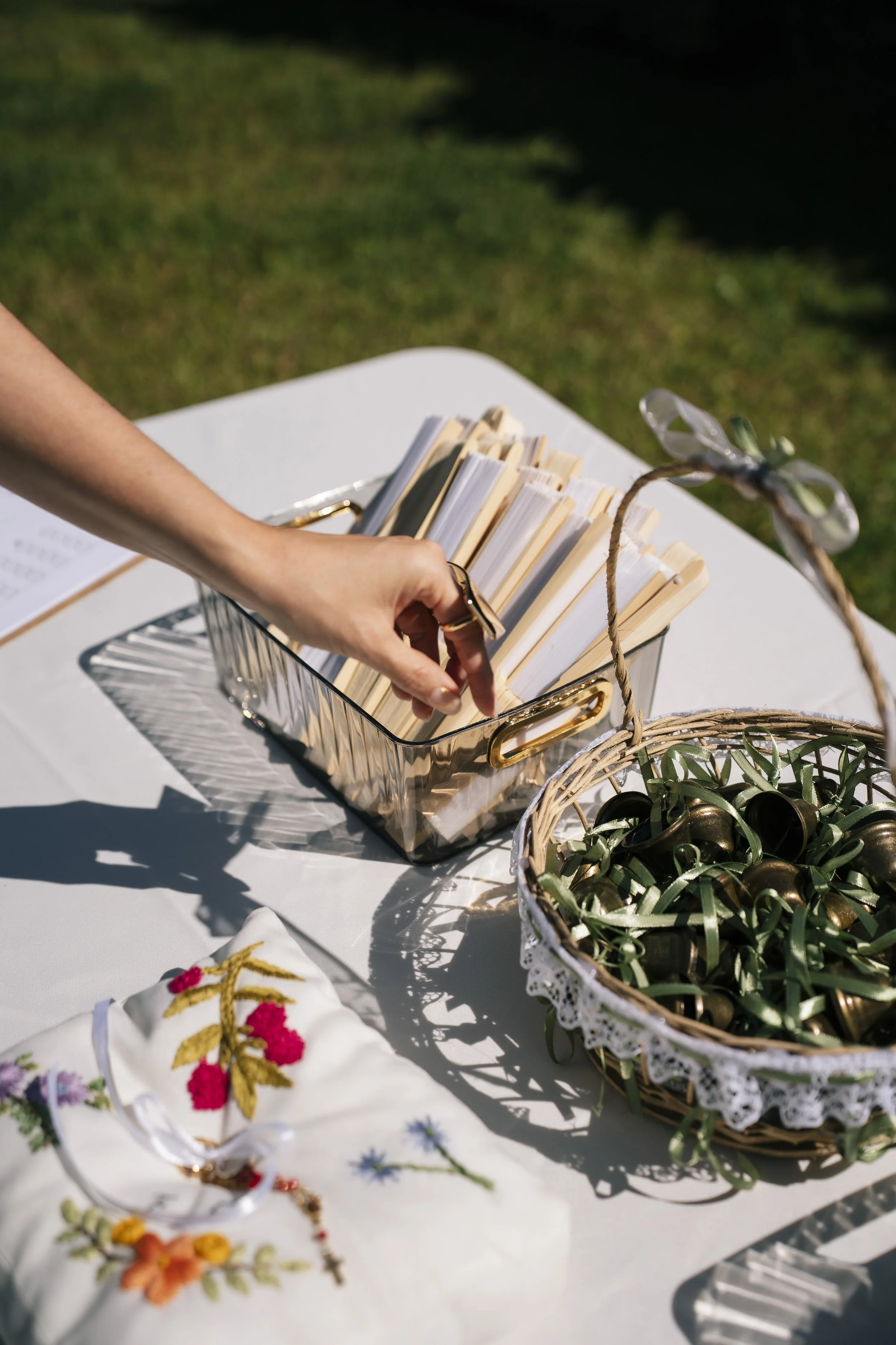 Mesa decorada con piezas bordadas, libros y detalles personalizados durante una boda en jardín en Costa Rica.