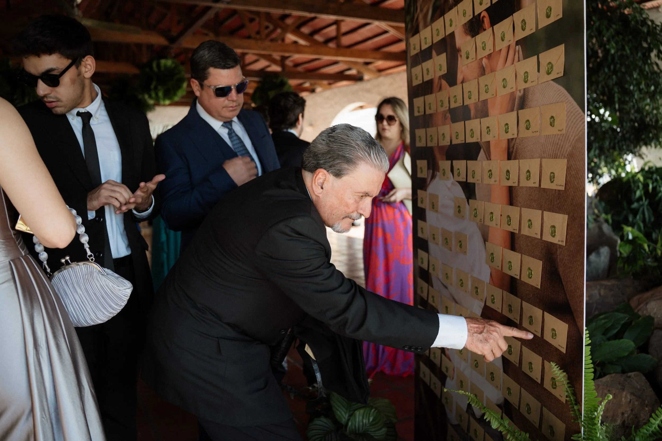 Pared de cartas personalizadas para invitados durante una boda al aire libre, como detalle especial de la experiencia.