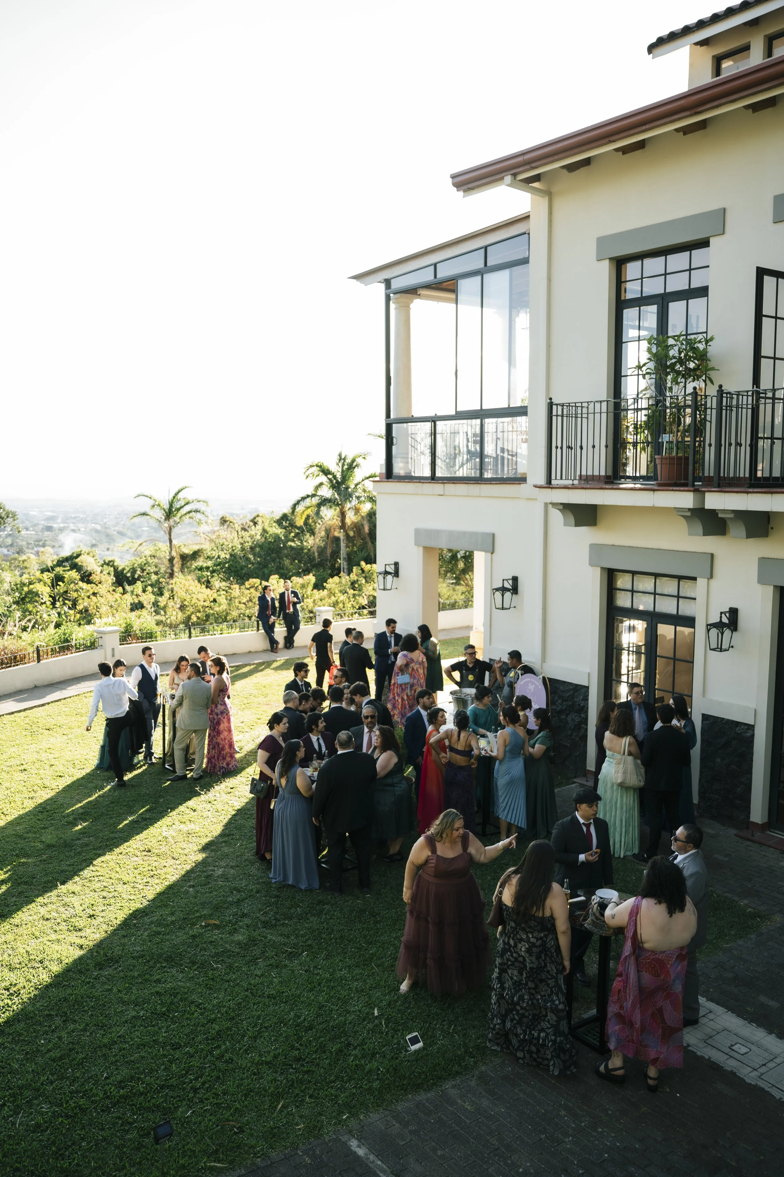 Invitados compartiendo al aire libre durante una boda en Costa Rica, rodeados de naturaleza y vista al paisaje.