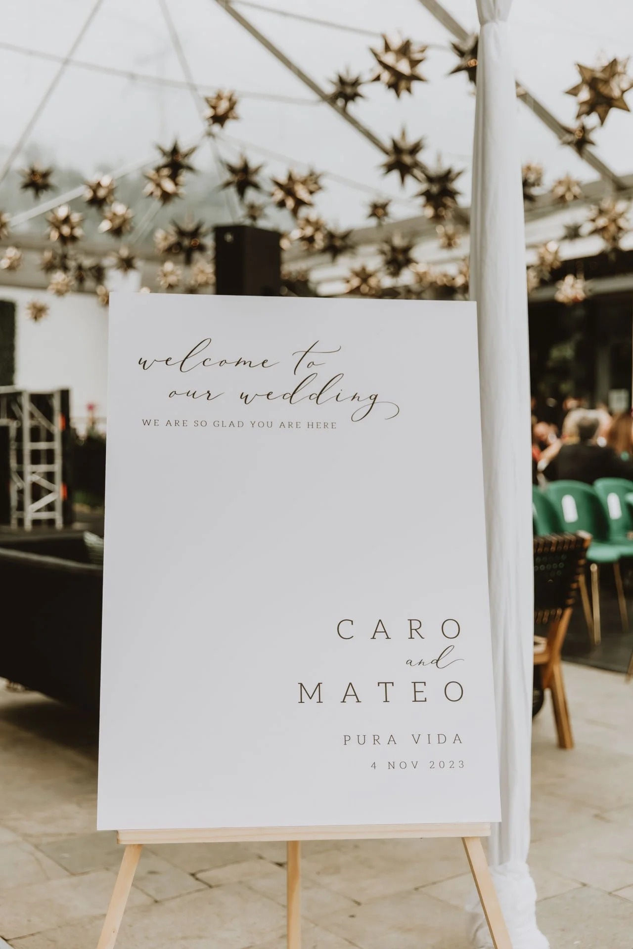 Señalización de bienvenida para la boda de Caro y Matteo, colocada en un venue al aire libre con luces decorativas en forma de estrella.