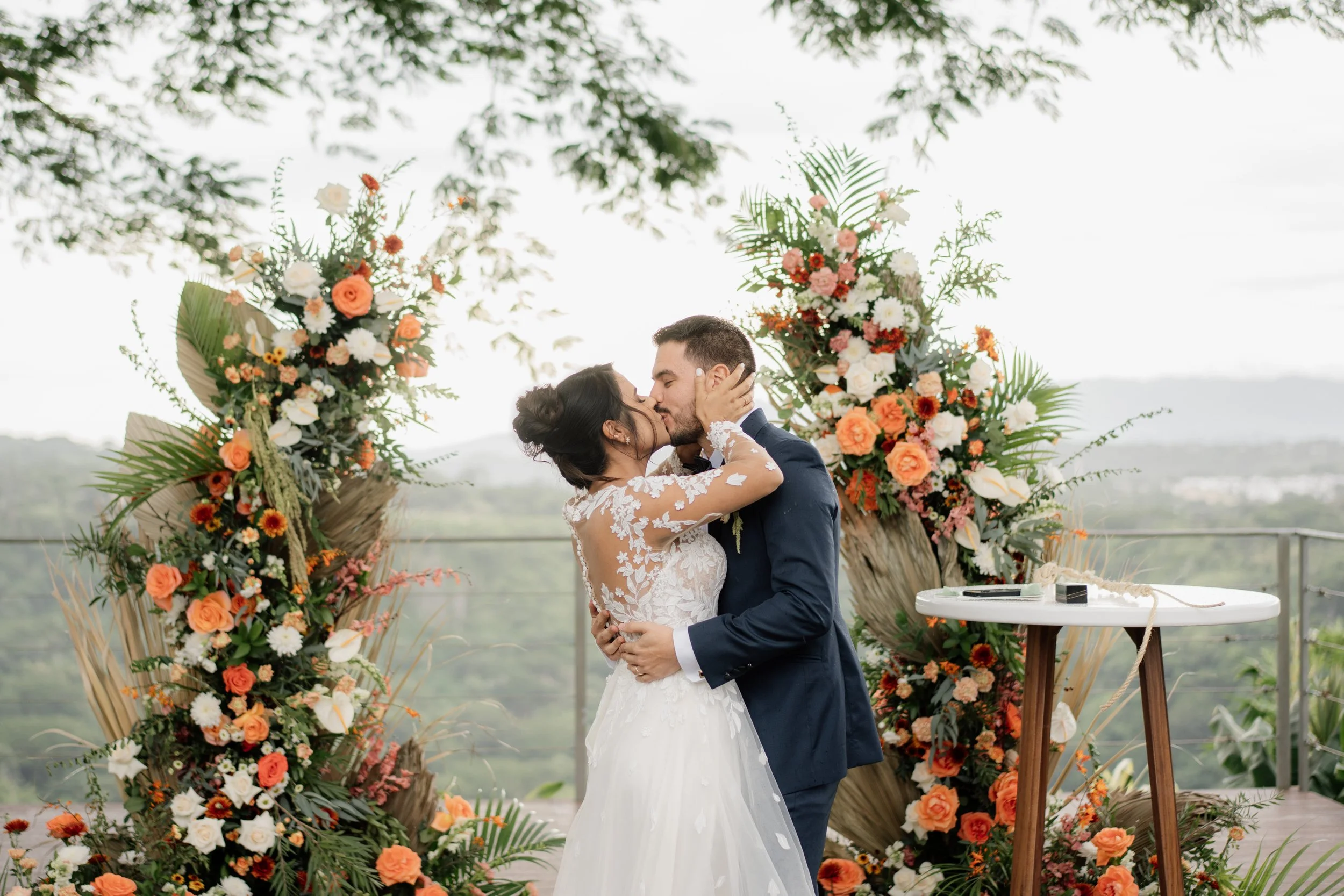 Novios de la boda Johnson Rodríguez besándose durante su ceremonia al aire libre, rodeados de flores y naturaleza en Casa Vista, Ciudad Colón.