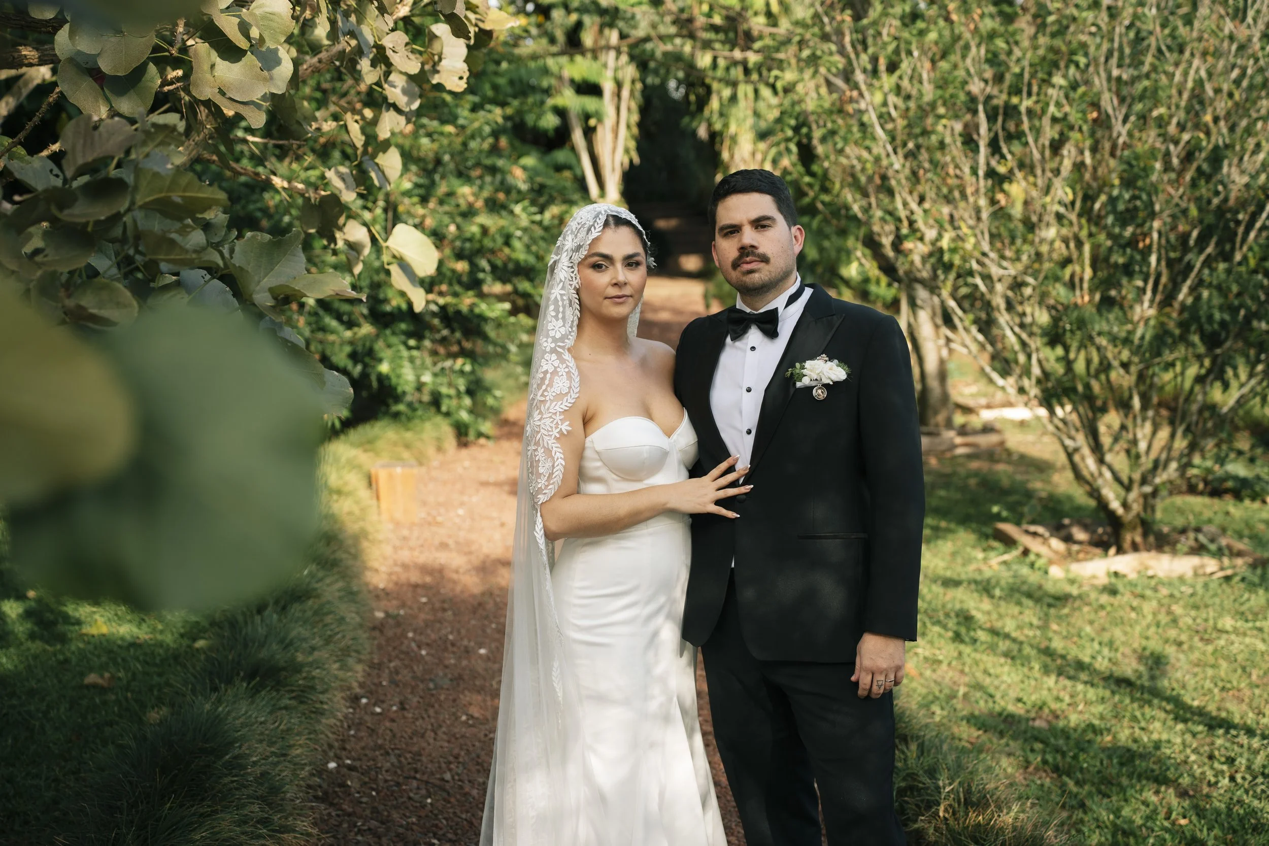 Retrato de los novios Murillo Fernández en un sendero rodeado de árboles y vegetación durante su boda en El Arca, Heredia.