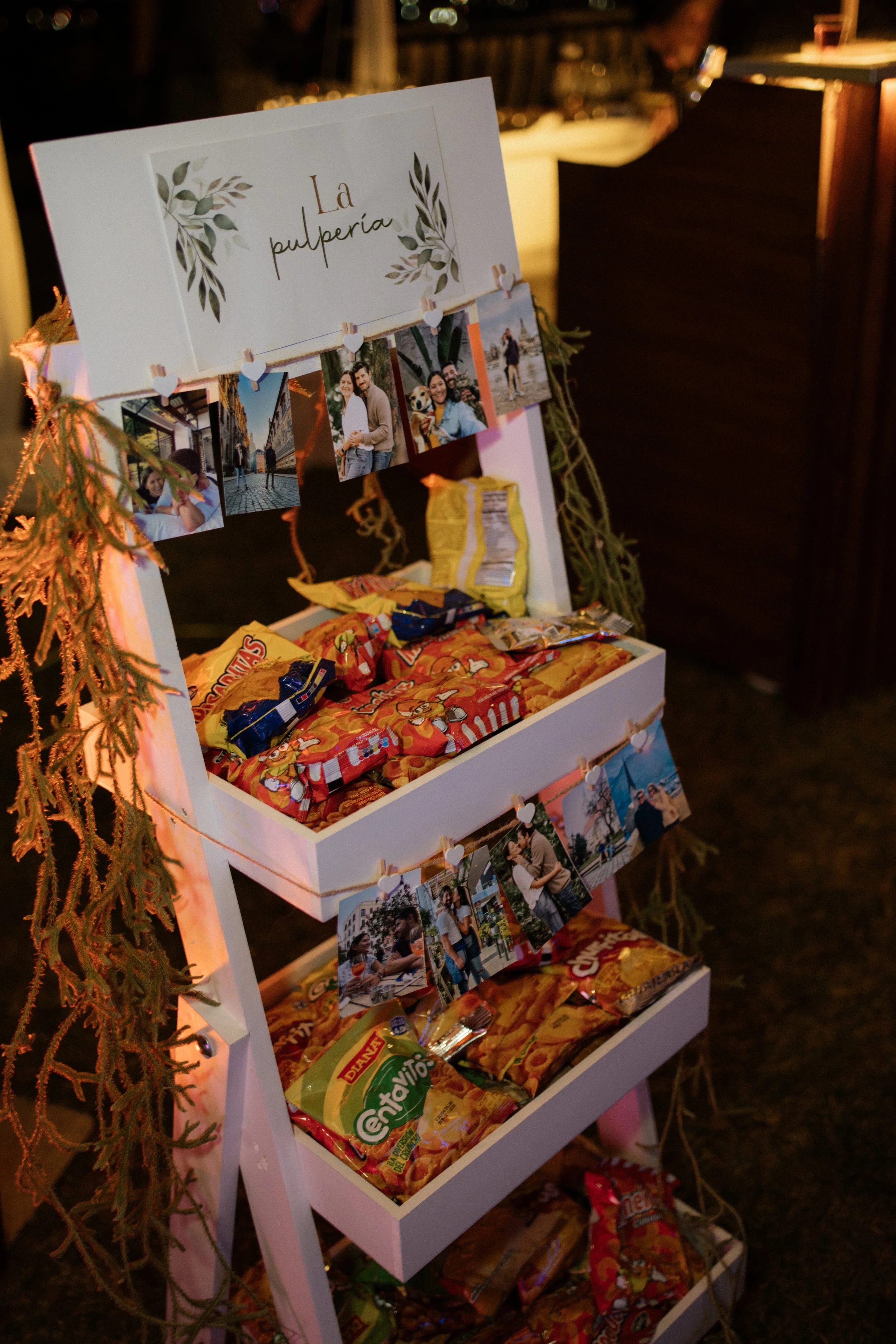 Estación de snacks tipo pulpería, decorada con fotos, dulces y detalles personalizados durante una boda en Costa Rica.