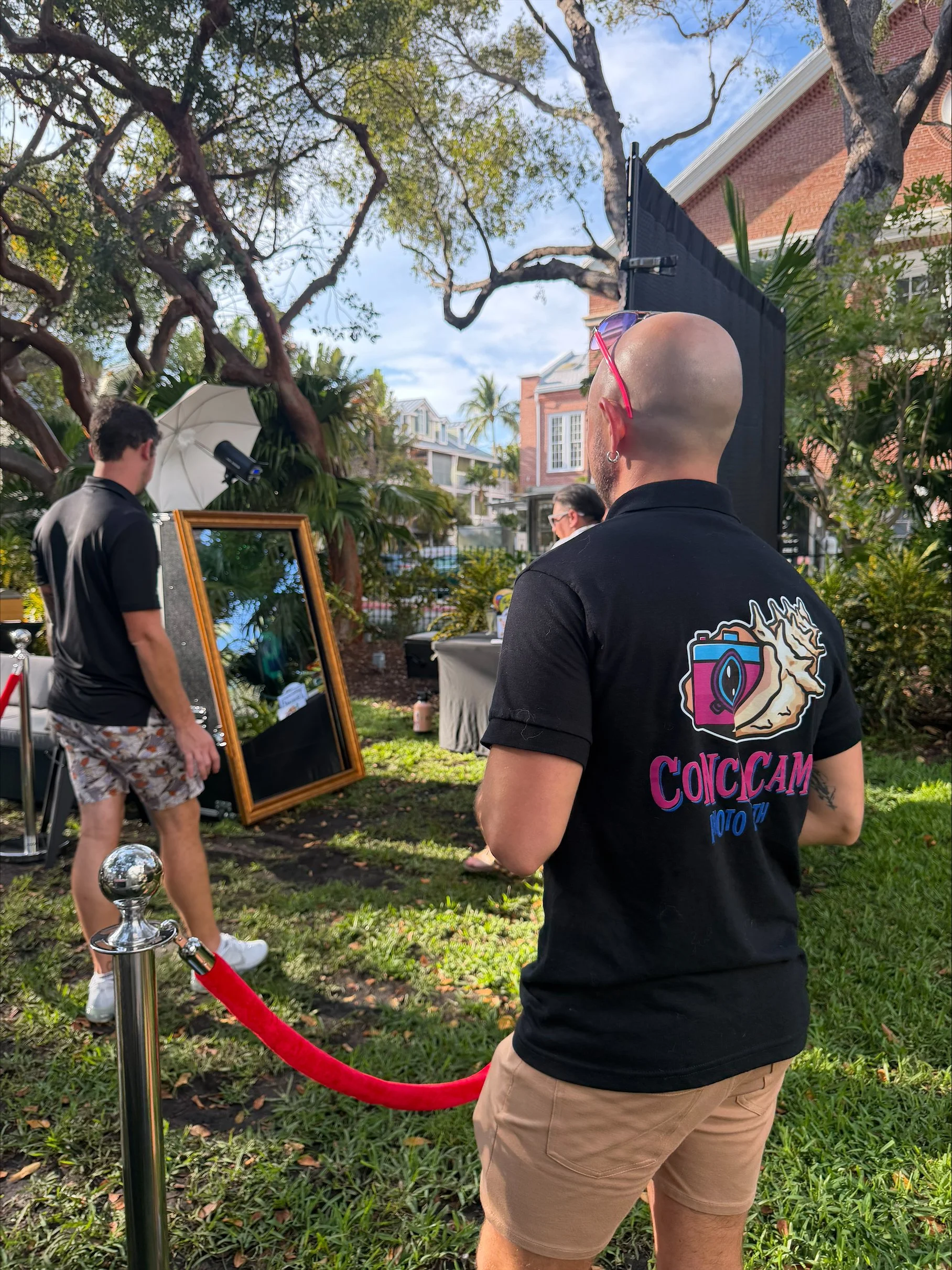The owner and staff watch as guests take a fun photo at the photo booth rental in Key West Florida provided by Conch Cam Photo Booth Rentals