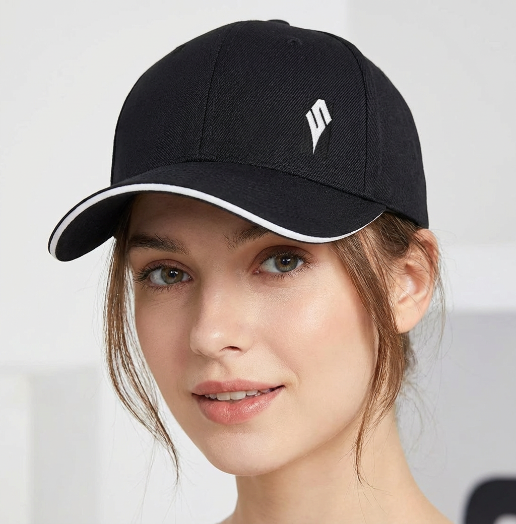 Close‑up of person wearing a black baseball cap with white piping and a small Scavenger logo