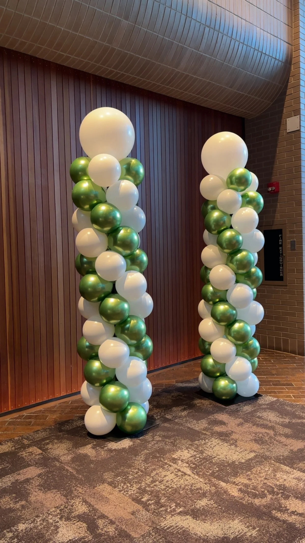 Decorative Balloon Columns with white and green balloons.